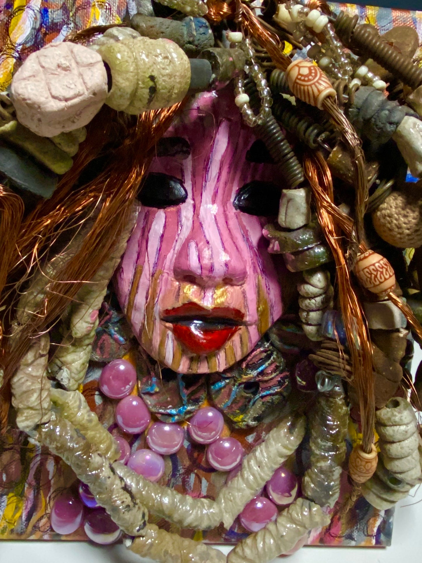 Sabra is mounted on a 8"x 10"painted canvas. I spent about 4 hours or more just fixing April's hair and attaching her beads! She has over 60 feet of 16 gauge wire with multiple strands of copper wire for hair and over 50 raku beads. Sabra has a striped pink crackle face with and ruby red lips. She is ready to be hung!