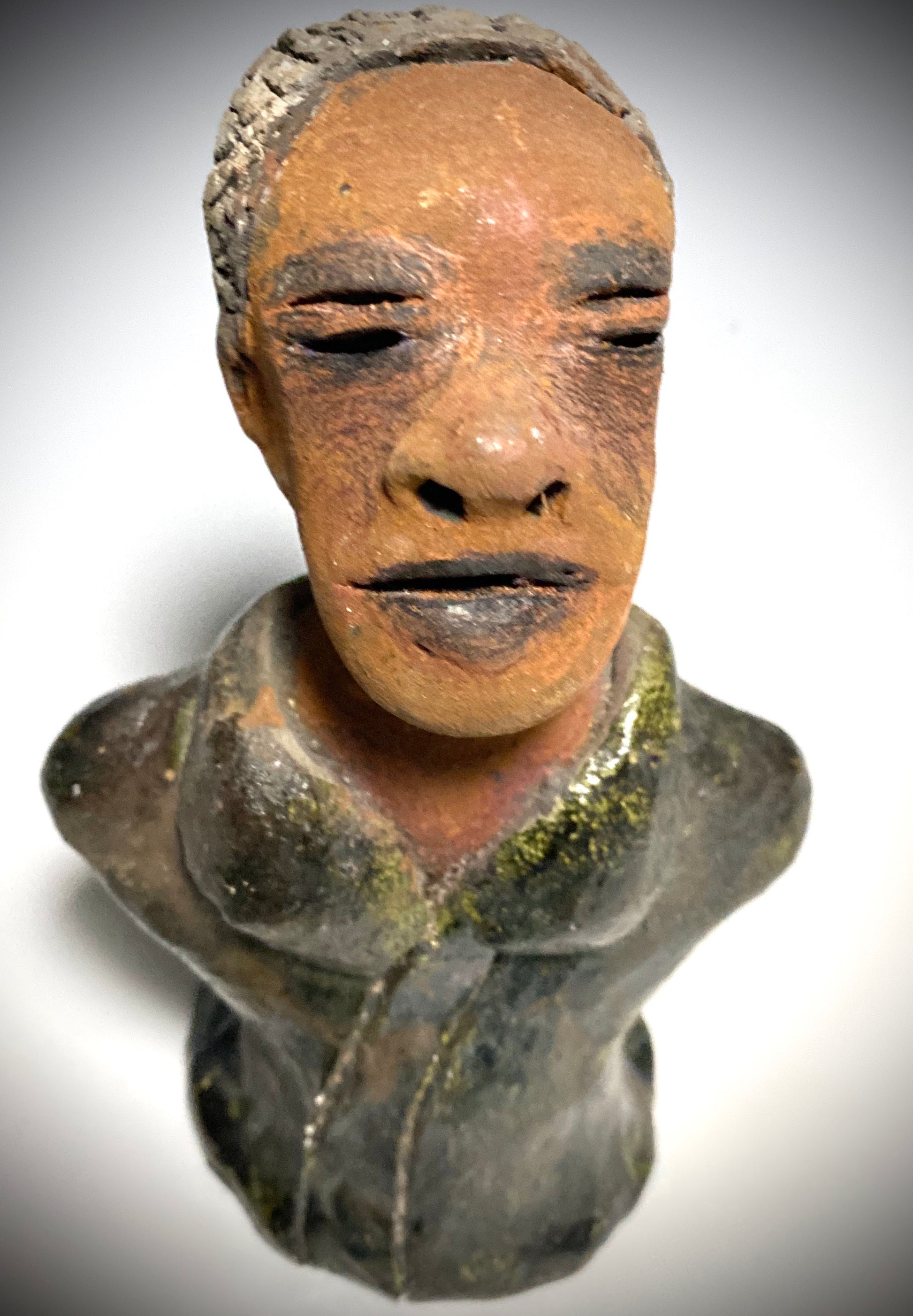 Mr. Charles has a story to tell!  Do you See the wisdom in his face? Mr. Charles  stands 5"x 3" x 2.5" and weighs 11 ozs. He wears a copper green metallic jacket. Mr. Charles's complexion is honey brown and he has salt and pepper hair.