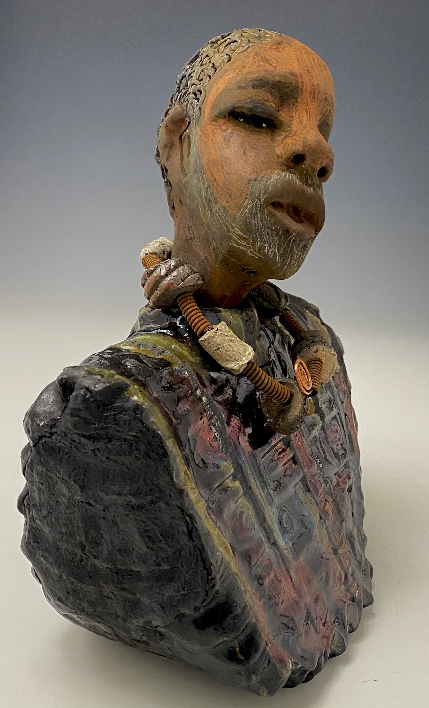 Meet James! James stands 10" x 7" x 5.5" and weighs 3.5lbs. James wears a colorful metallic gold, blue and copper dashiki. He is bald and bearded and partially grey. Yes ,,,,,,He is one of few Men found in the Herdew collection!