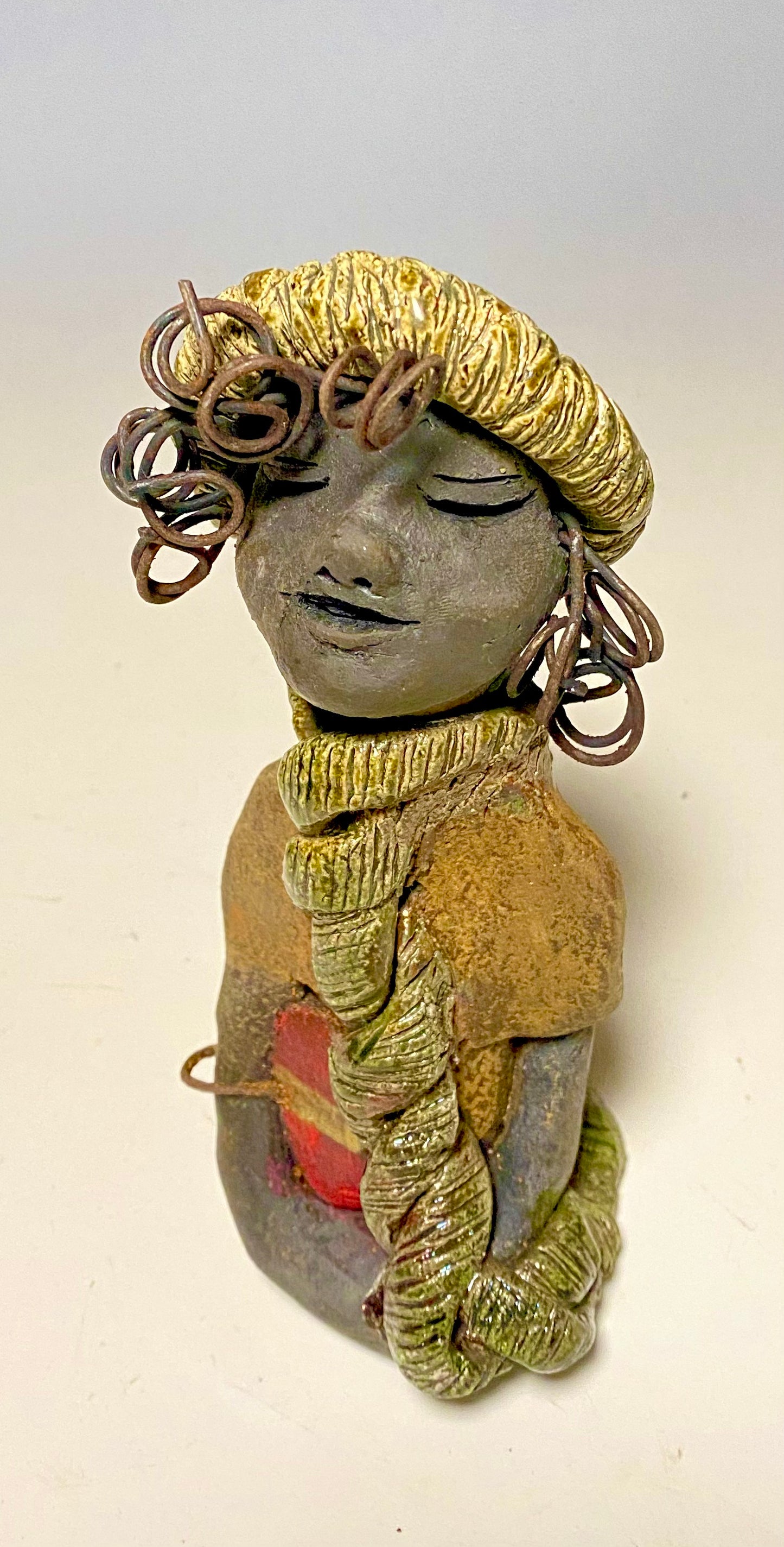 Meet Edna! Edna stands 6" x 3.5”x 4" and weighs 12.4 ozs. She has a dark lovely smokey black complexion. Edna has a glossy green and copper metallic dress. She clinches her designer Dark red purse. Edna wears a designer hat as well. With the current situation we All are going through, Edna will place a smile on your face during this challenging time. If not return Edna within 30 days after receiving her for a complete refund.