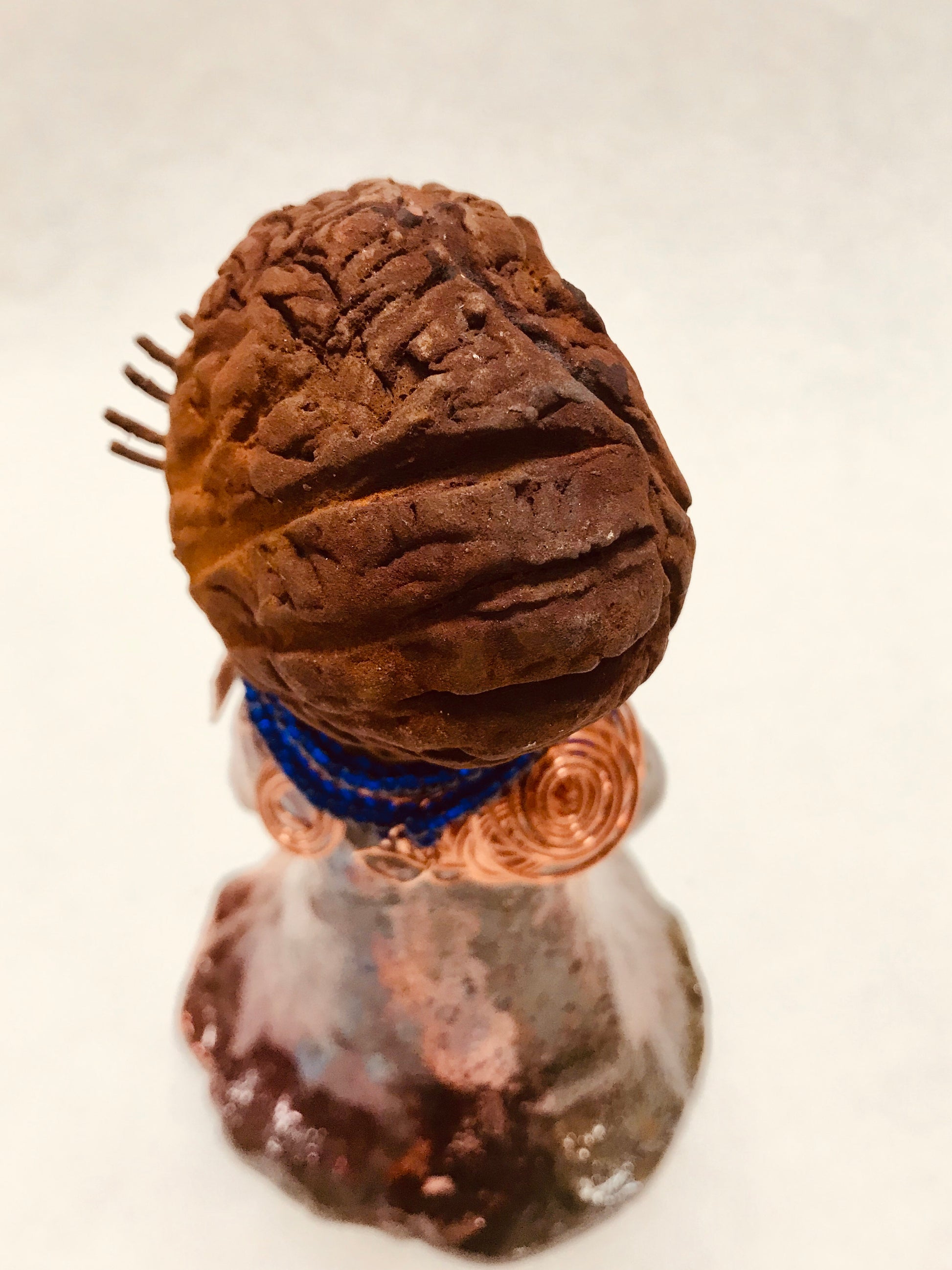 Tattayana stands 8" x 4.5" x 5" and weighs 1.02  lbs. She has a lovely honey brown complexion with reddish brTattayanaown lips. She has a short braided hairstyle.  Tattayana has a colorful metallic antique copper glazed dress. She wears spiral copper wire necklaces on top of an aqua blue beaded collar.  Tattayana has her long loving arms rest at her side. With eyes wide opened,Tattayana  has hopes of finding a new home.