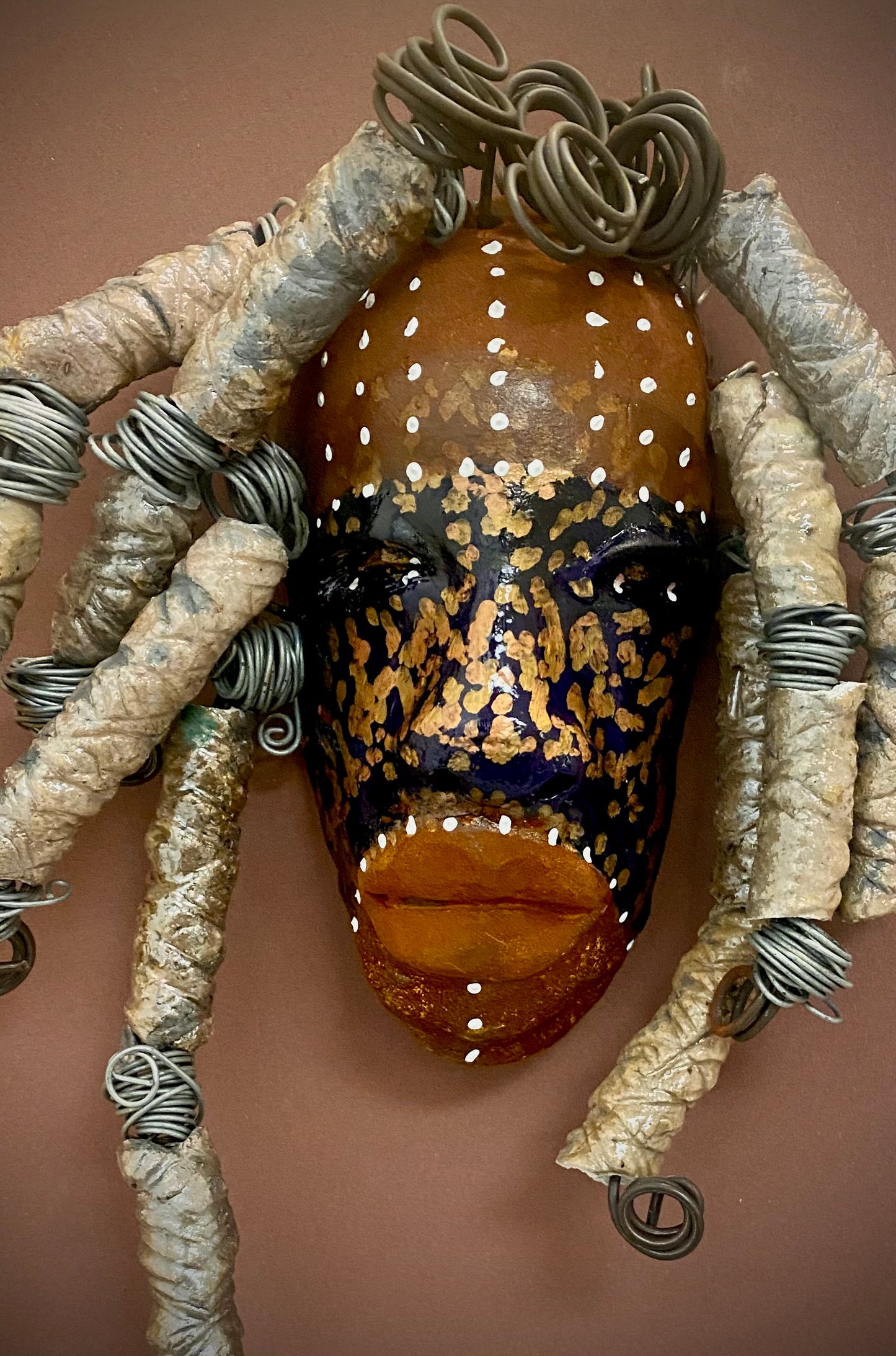 Meet Aku! I started making art soon after seeing authentic African artwork at the Smithsonian Museum of African Art. I was in total awe. Aku was inspired by my visit there. Aku has an awesome blue, brown, and speckled gold complexion. He is 5”x 7”" and weighs 9 ozs. Aku has over 10 feet of coiled 16 gauge copper wire hair.