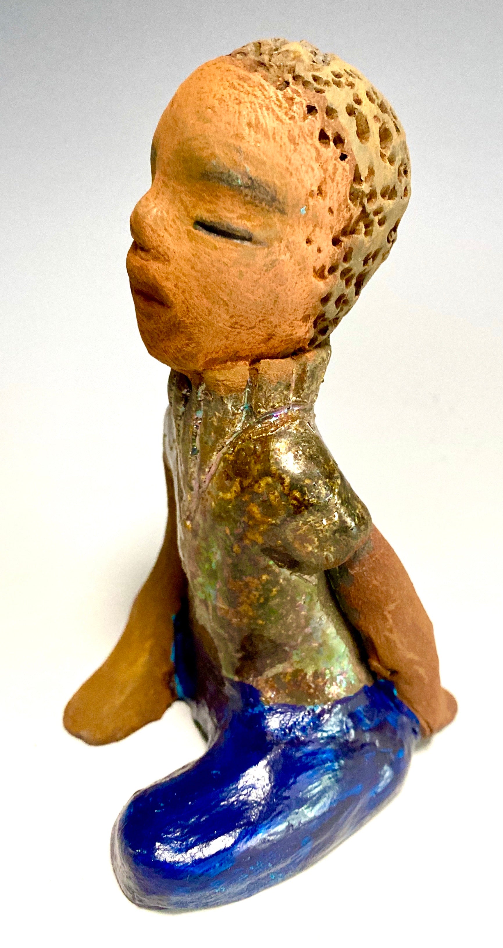 Anthony is one confident preteen who is ready to get back to school!     Anthony stands 5" x 4" x 4" and weighs 12 ozs. He has a metallic green and gold shirt with blue jeans . Anthony complexion is honey brown. He has a  youg gentle spirit One arms is  behind his back as he ponders who will be his favorite teacher.