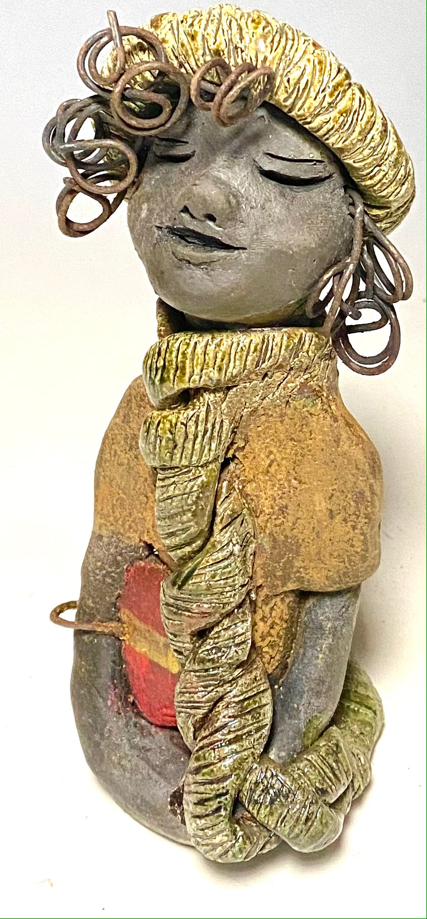 Meet Edna! Edna stands 6" x 3.5”x 4" and weighs 12.4 ozs. She has a dark lovely smokey black complexion. Edna has a glossy green and copper metallic dress. She clinches her designer Dark red purse. Edna wears a designer hat as well. With the current situation we All are going through, Edna will place a smile on your face during this challenging time. If not return Edna within 30 days after receiving her for a complete refund.