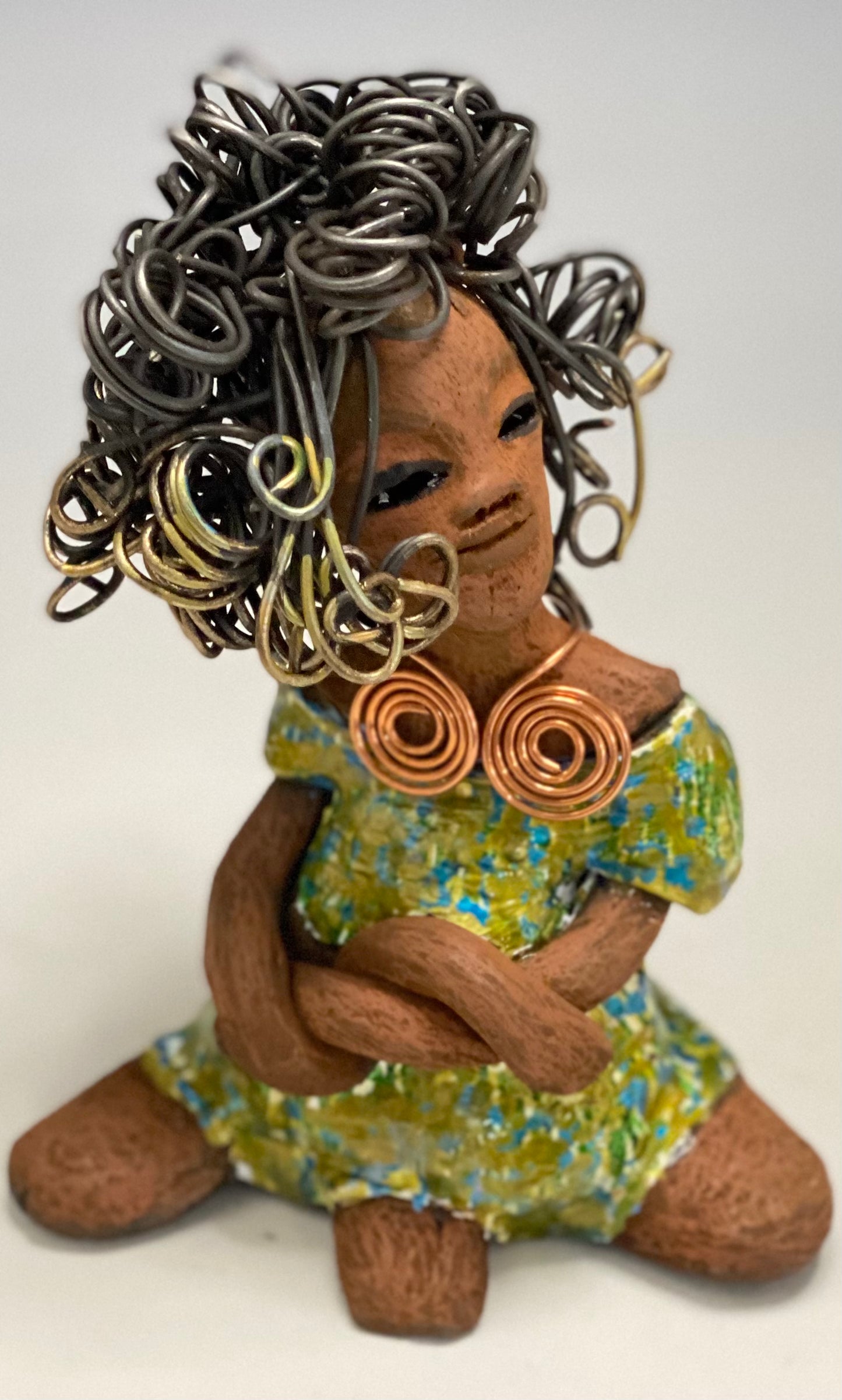 Jayla stands 7" x 5" x 4.5" and weighs 14 ozs. She has a lovely honey brown complexion with cocoa brown lips. She has a big hairstyle! Brianna has a colorful blue green antique glazed dress. She has over 15 feet of 16 gauge wire for hair. It took over 2hours just to do her hair! With eyes wide opened, Jayla has hope of finding a new home. You will love having Jayla! She will attract and spark conversation with guest in your home!