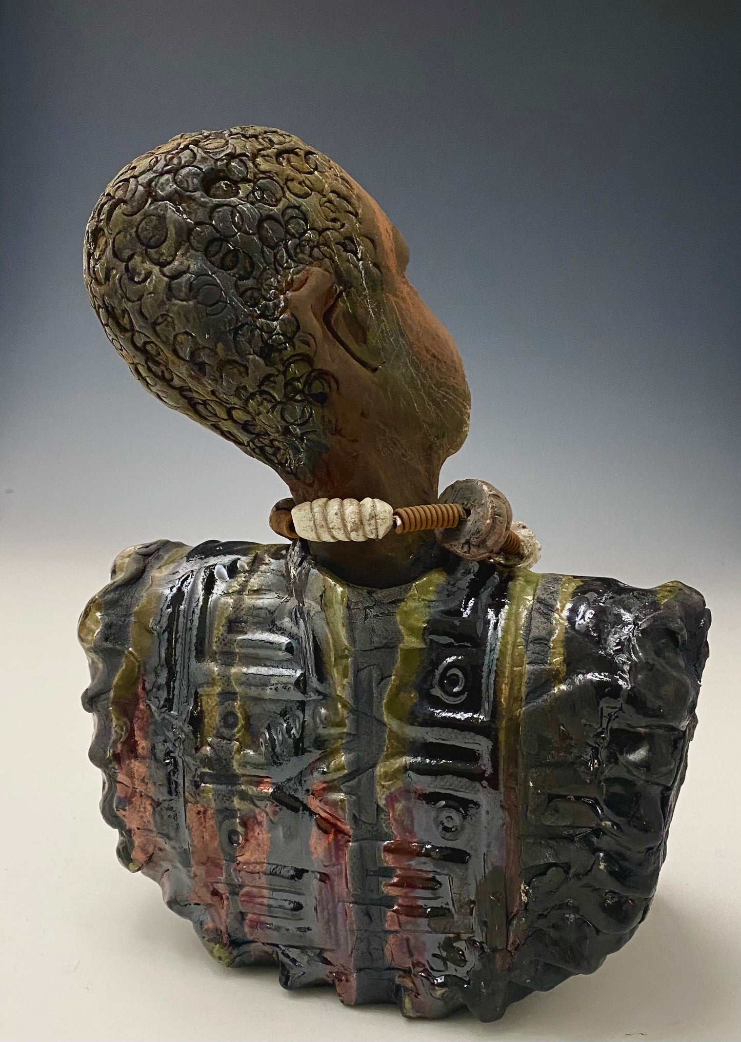 Meet James! James stands 10" x 7" x 5.5" and weighs 3.5lbs. James wears a colorful metallic gold, blue and copper dashiki. He is bald and bearded and partially grey. Yes ,,,,,,He is one of few Men found in the Herdew collection!