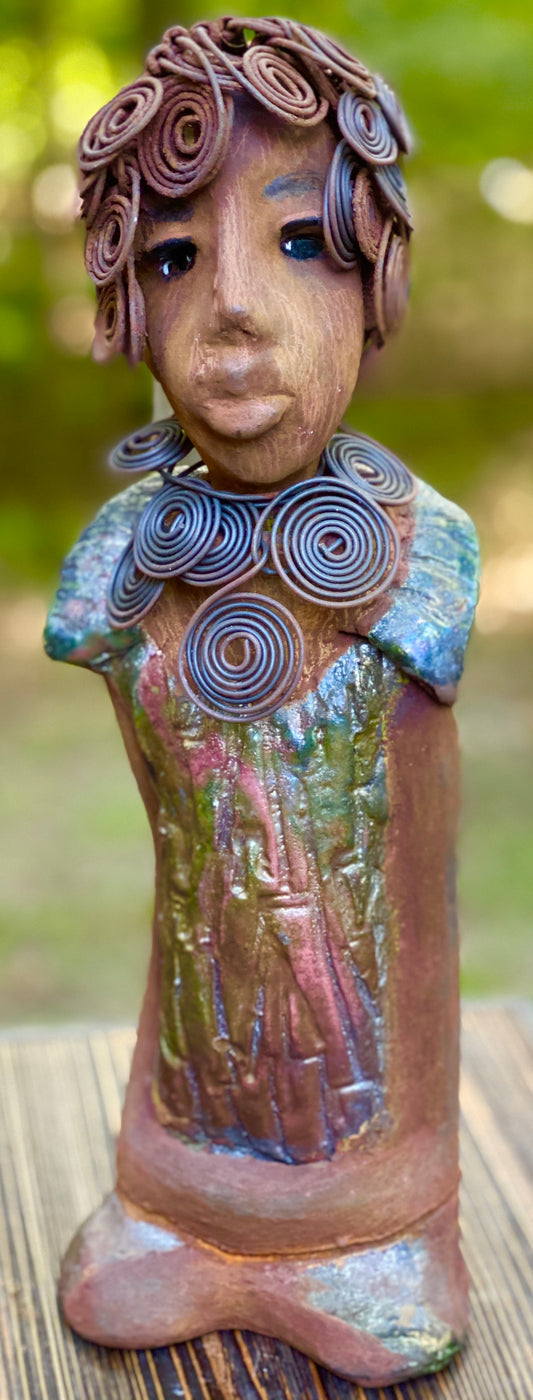 Meet Farida! Farida stand 13”x 5” x 4” and weighs 4 lbs. She has a bright eyes and a beautiful honey brown complexion. Farida has a fancy over the top Herdew. It took two hours to complete! A spiral 16 gauge necklace wraps around her neck. Her dress is a textured metallic green. Farida is looking for a new home.She would make a great gift to a BFF or just for YOU!