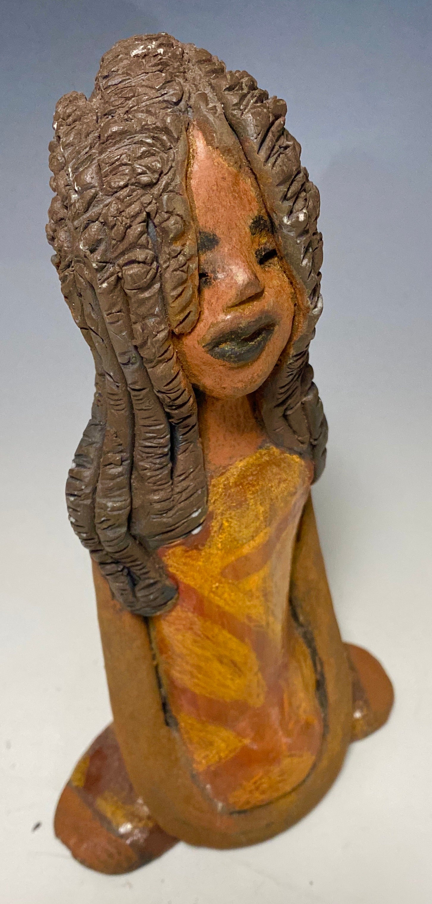 Meet Bree! Bree stands 7.5' x 4.5" x 2.5" and weighs 11 ozs. She has a lovely honey brown complexion. Bree wears a golden brown striped dress. Her hair is smokey black .and made of clay. Bree's long loving arms rest at her side.