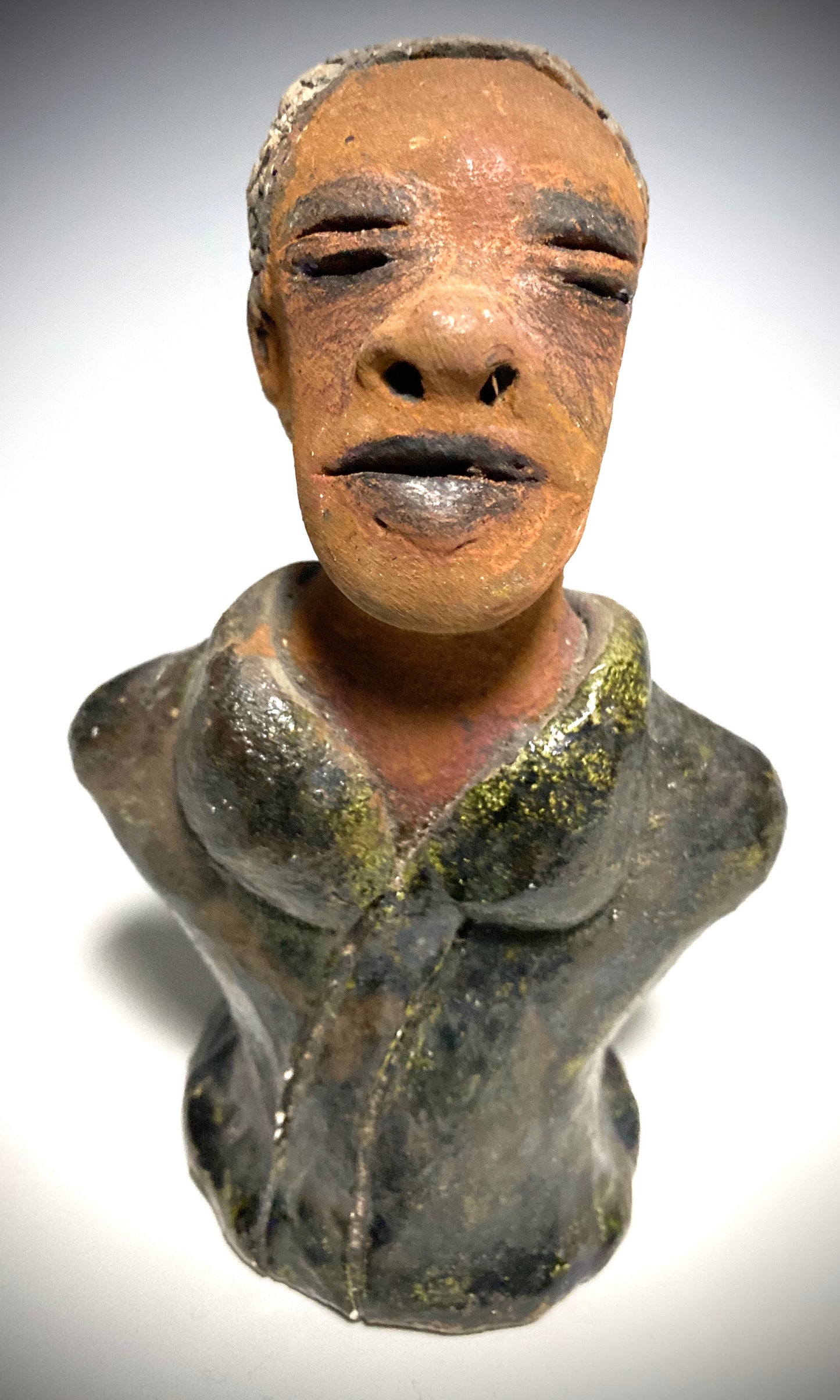 Mr. Charles has a story to tell! Do you See the wisdom in his face? Mr. Charles stands 5"x 3" x 2.5" and weighs 11 ozs. He wears a copper green metallic jacket. Mr. Charles's complexion is honey brown and he has salt and pepper hair.