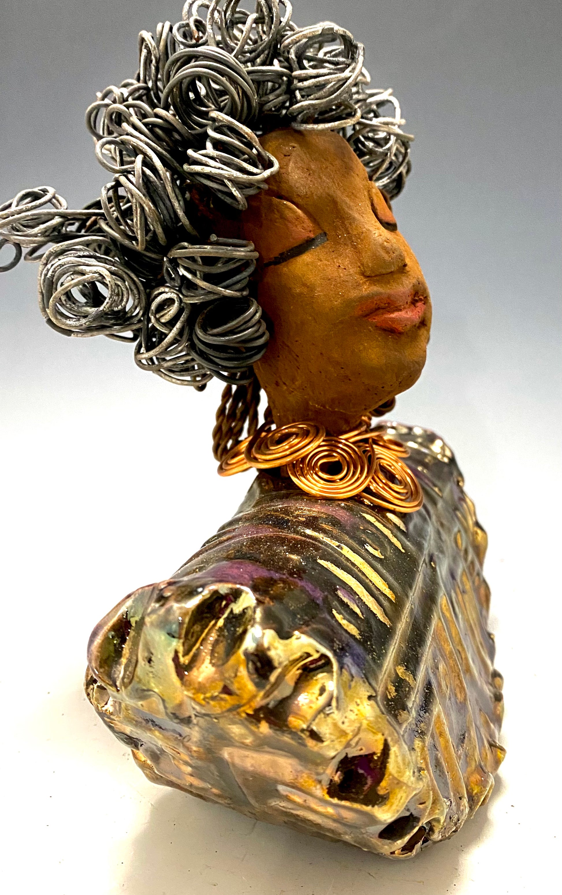 Meet Janet!  Janet looks up with joy and anticipation! She  stands 8" x 7" x 4" and weighs 2.70 lbs. She has a beautiful textured gold and  copper robe trim. Janet has braided ,twisted, and curled wire hair. She has a honey brown complexion and soft reddish brown lips. Janet will make for great conversation in your home.