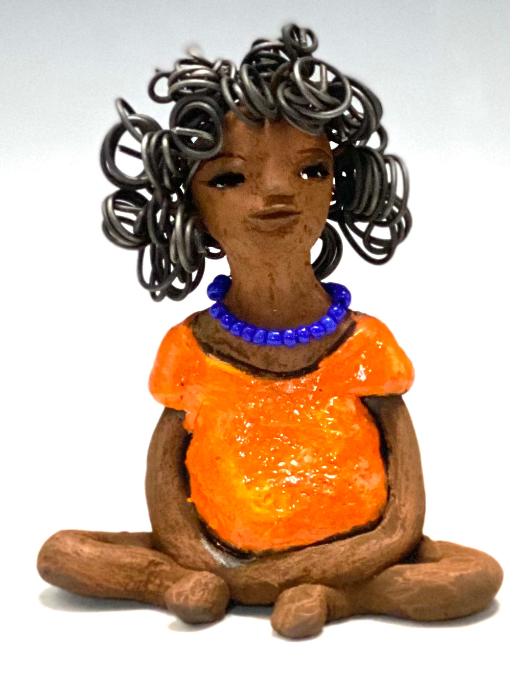 Asia stands 5" x 4" x 3.5" and weighs 8.75 ozs. She has a lovely honey brown complexion with cocoa brown lips. She has a really big curly hairstyle! Asia has beautiful a orange dress dress accented with a blue beaded necklace! . She has over 15 feet of 16 gauge wire for hair. It took over 2 hours just to do her hair! With eyes wide opened, Asia has hope of finding a new home.
