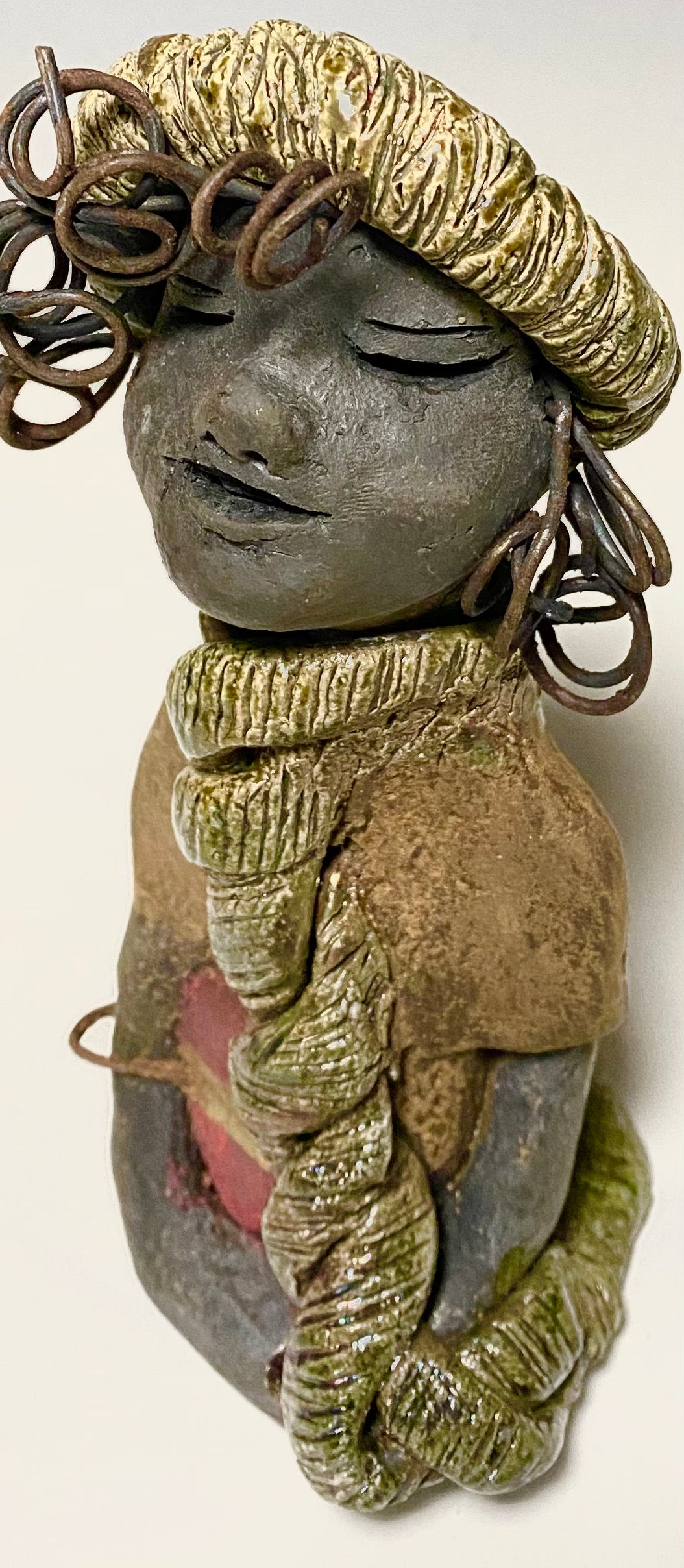 Meet Edna! Edna stands 6" x 3.5”x 4" and weighs  12.4 ozs.  She has a dark lovely smokey black complexion. Edna has a glossy green and copper metallic dress.  She clinches her designer  Dark red purse. Edna wears a designer hat as well. With the current situation we All are going through,  Edna will place a smile on your face during this challenging time.  If not return Edna within 30 days after receiving her for a complete refund.
