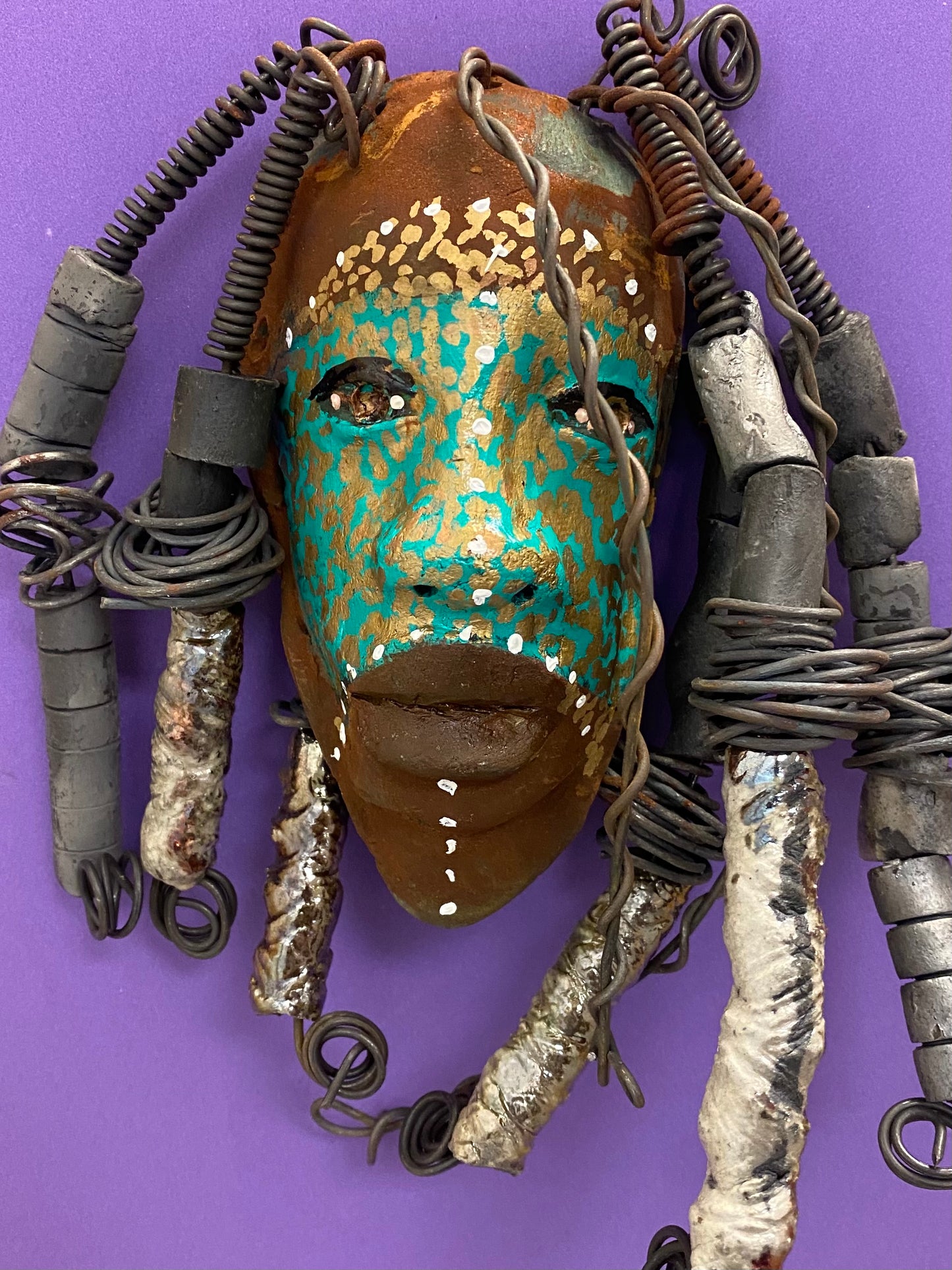 Meet Kanumba! I started making art soon after seeing authentic African artwork at the Smithsonian Museum of African Art. I was in total awe. Kanumba was inspired by my visit there. Kanumba has an awesome earthy green tribal scarification complexion. He is approximately 8" x 8" and weighs 13 ozs. Kanumba has an handmade textured off white clay and metallic dreadlocks along with twist of coiled 16 gauge wire.