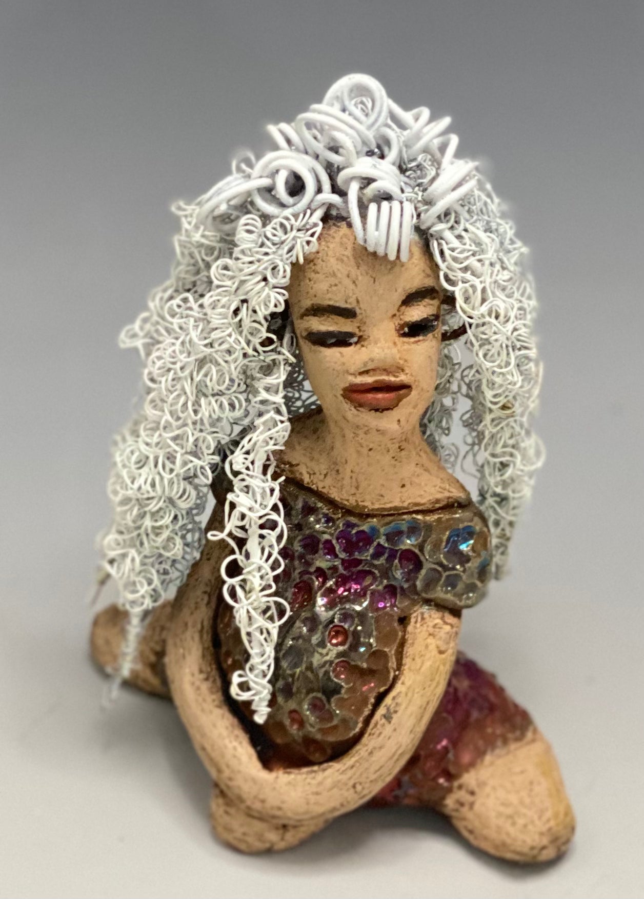 Alyssa stands 6" x 5" x 5" and weighs 12 ozs. She has a lovely honey brown complexion with cocoa brown lips. She has long twisted  white wire locs hairstyle waist down!  Alyssa has a metallic  copper antique glazed dress. She has over 75 feet of 16 and 24 gauge white wire for hair. It took over 3 hours just to do her hair! With  eyes wide opened, Brianna has hope of finding a new home.     You will love having Alyssa. She will attract and spark conversation with guest in your home!