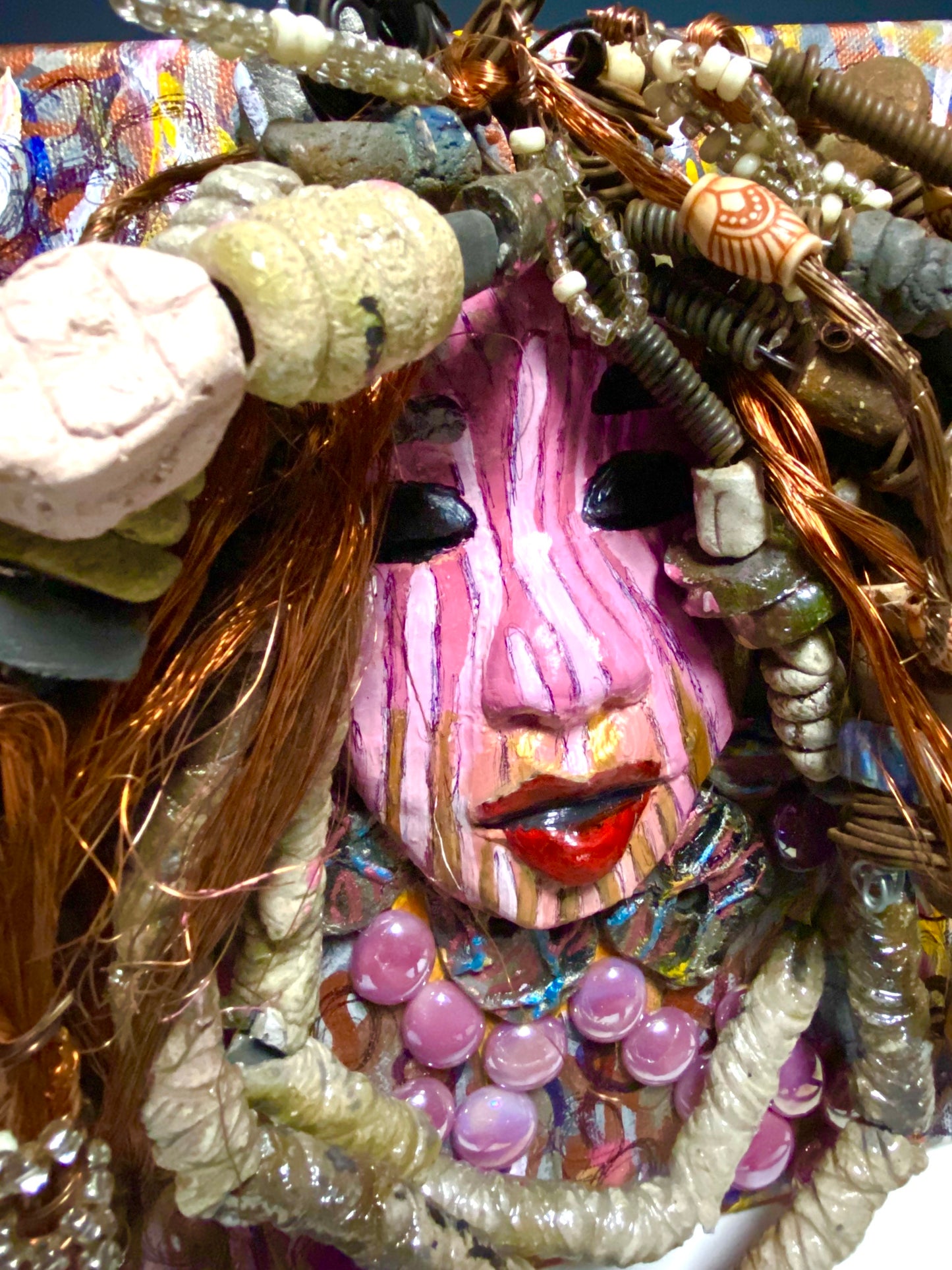 Sabra is mounted on a 8"x 10"painted canvas. I spent about 4 hours or more just fixing April's hair and attaching her beads! She has over 60 feet of 16 gauge wire with multiple strands of copper wire for hair and over 50 raku beads. Sabra has a striped pink crackle face with and ruby red lips. She is ready to be hung!