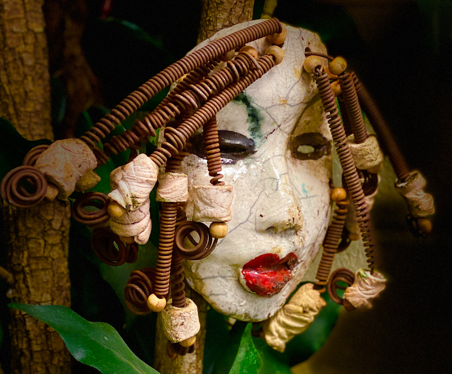 Larandra has a white crackle complexion. She is 6" x 5" and weighs 1.6 lbs. Larandra has over 20 feet of coiled 16 gauge wire hair and several wooden and white raku beads.