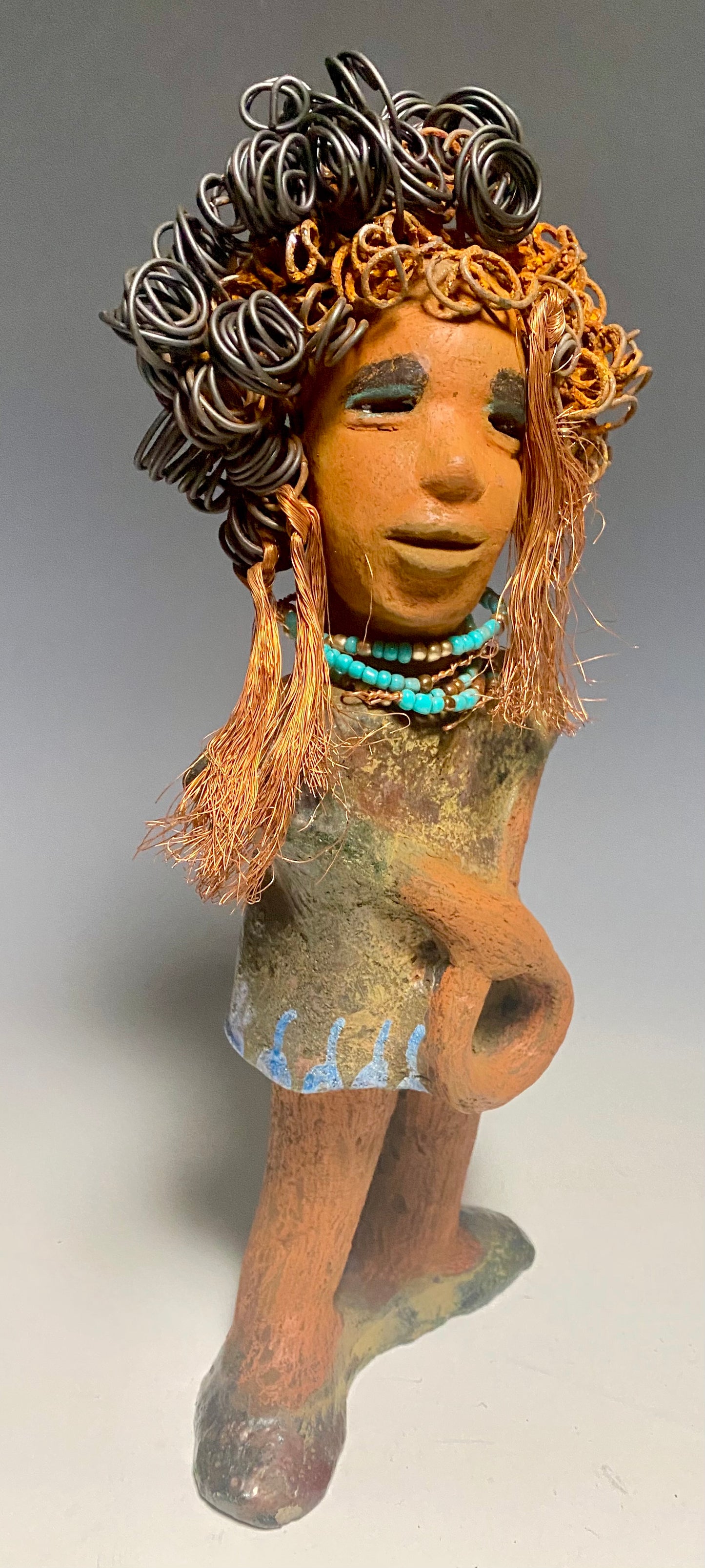 Meet Ernestine! What a joy to be around a young lady like Ernestine! She is one of many who has a polite gentle spirit! Ernestine stands 13" x 5" x 4" and weighs 3.19 lbs. Ernestine has a lovely honey brown complexion. Her hair is made of multiple strands of thin copper wire and two tone black and rusted 16 gauge wire. She has a textured colorful copper metallic dress. Ernestine is a young woman full of pride and joy. If you like sophisticated sculptures, Ernestine will bring joy and peace to your home.