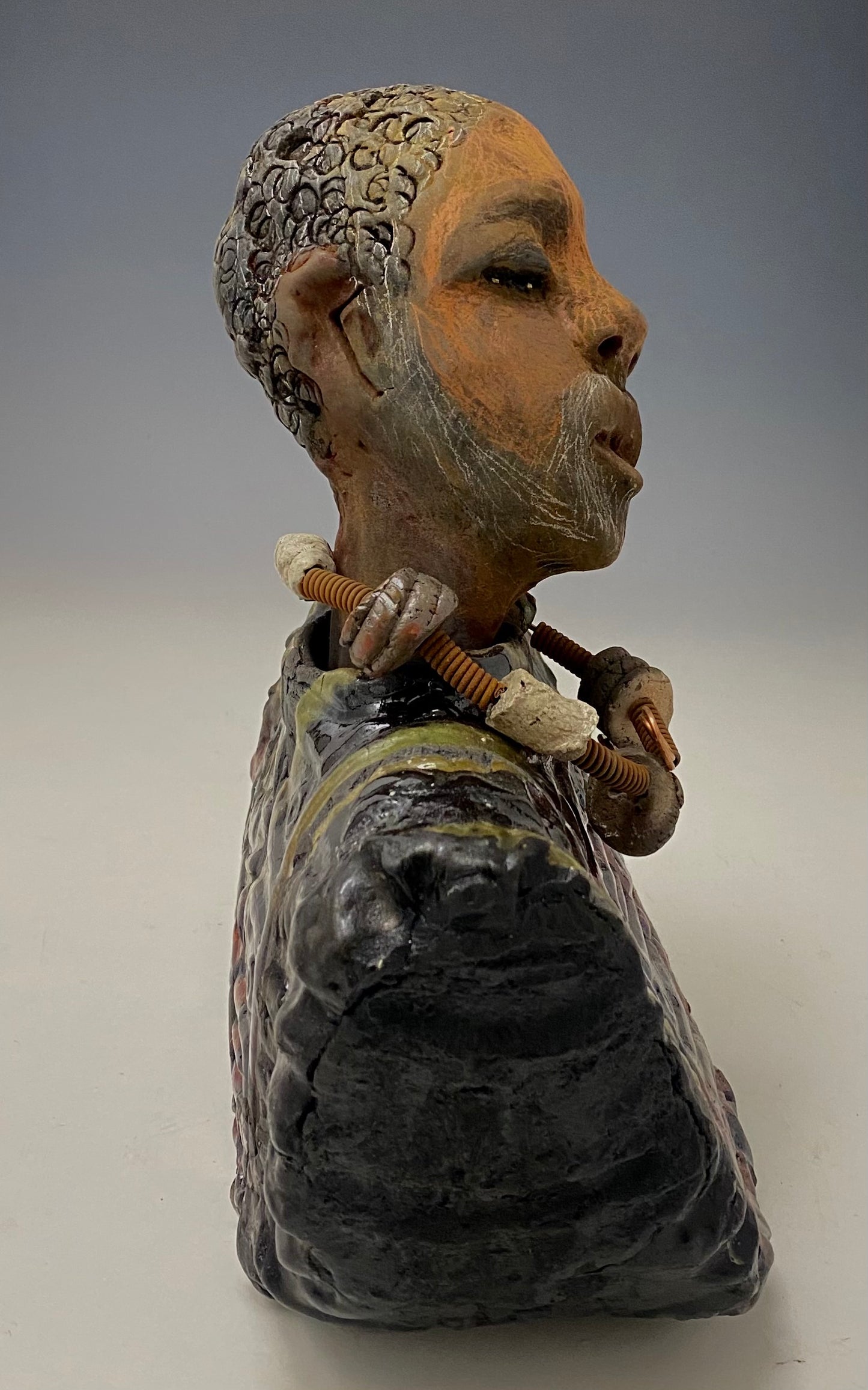 Meet James! James stands 10" x 7" x 5.5" and weighs 3.5lbs. James wears a colorful metallic gold, blue and copper dashiki. He is bald and bearded and partially grey. Yes ,,,,,,He is one of few Men found in the Herdew collection!