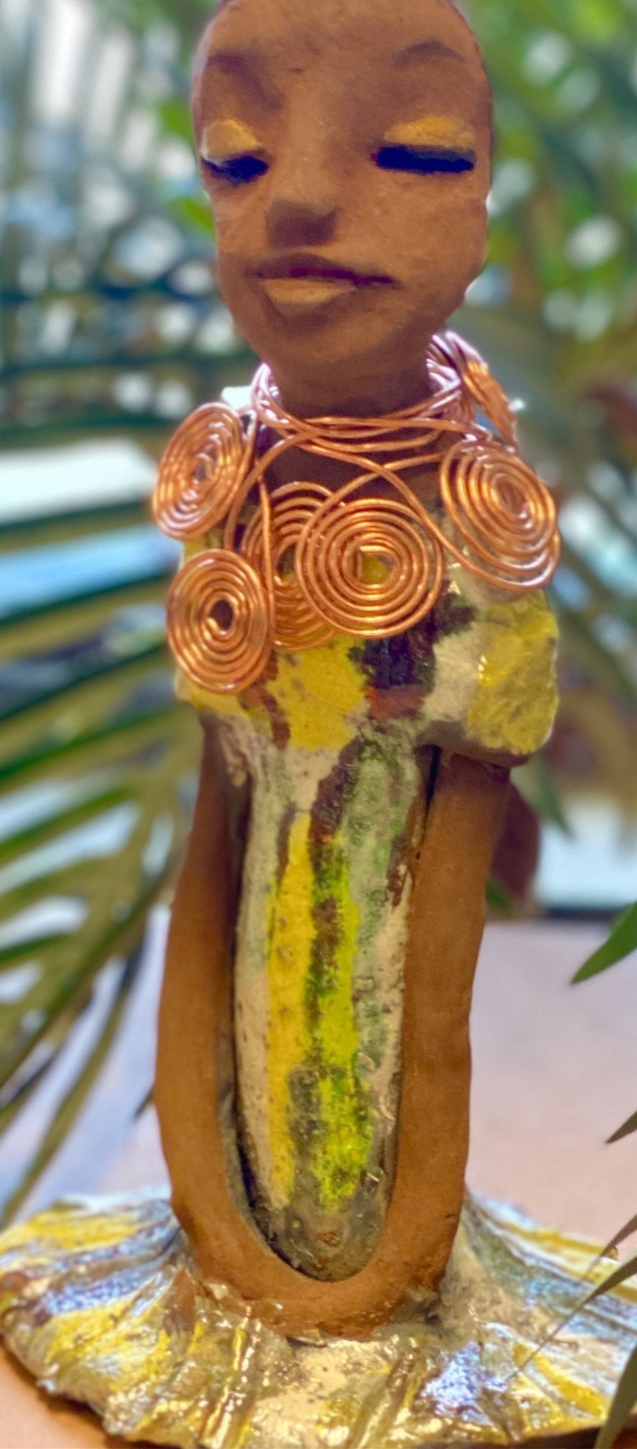 Meet Trisha! Trisha stands 9.5" x 5”x 5" and weighs 1.3 lbs. Trisha has a lovely glossy yellow green dress with a copper spiral necklace. Her hair is etched in clay. Her long arms rest at her side. Trisha is at a special low price. This makes her an excellent starter piece from the Herdew Collection!