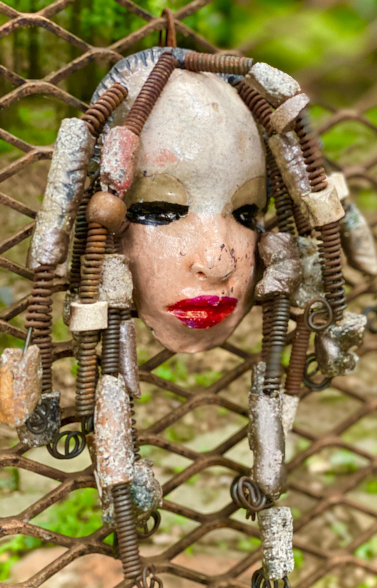 I started making art soon after seeing authentic African artwork at the Smithsonian Museum of African Art. I was in total awe. Ireland was inspired by my visit there. Ireland weighs 13 ozs. Her face is formed with hand coiled wire and raku beads Ireland's face is two tone and beams with pale pink crackle glaze and ruby red lips.