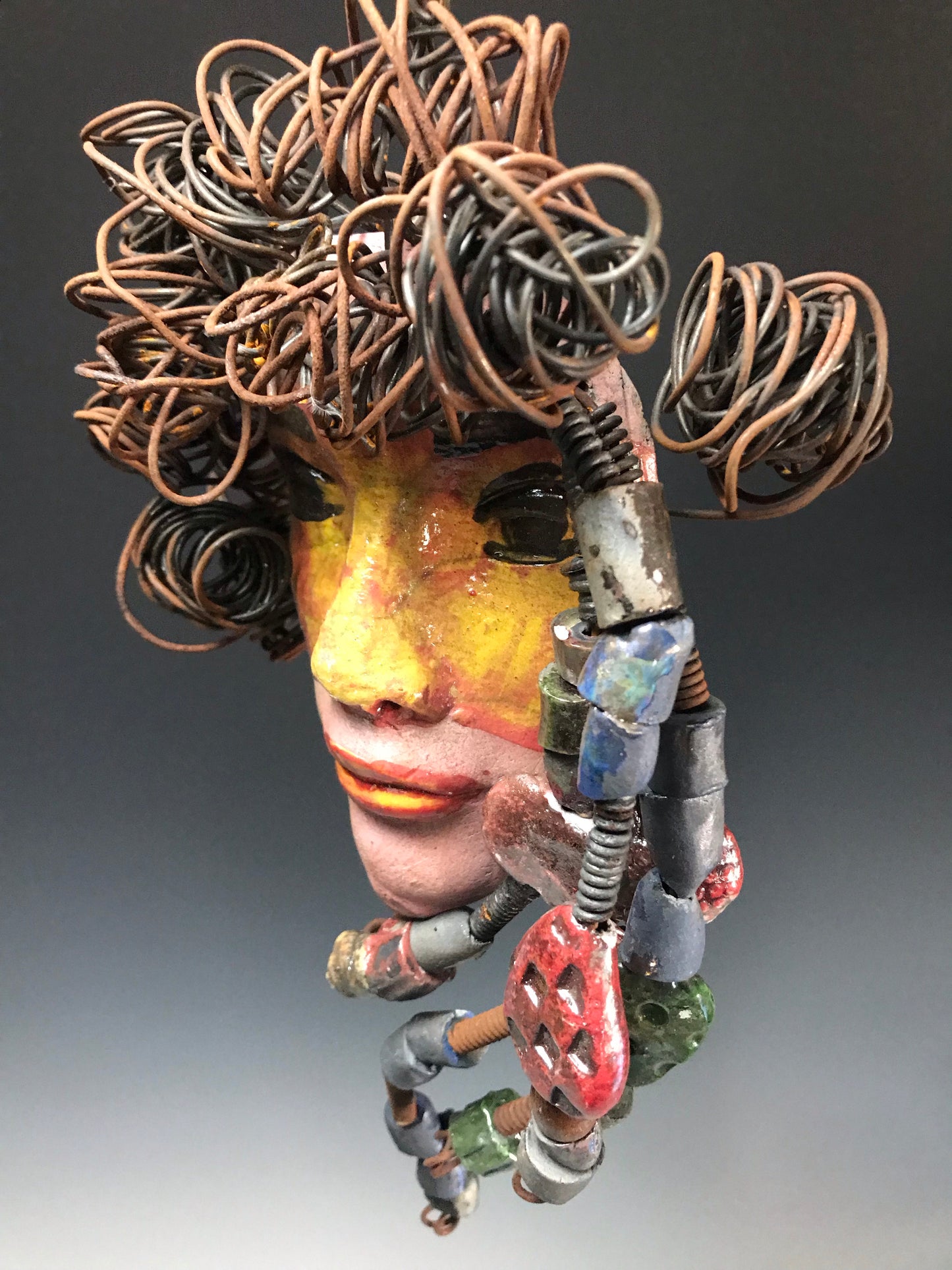 Meet Quisha! I started making mask after seeing an authentic African Mask collection at the Smithsonian Museum of African Art. I was in total awe. Quisha was inspired by my visit there. Quisha has a complexion of mustard and honey brown. She is 7" x 12" and weighs 1.3 lbs. Quisha has over 40 handmade raku fired beads. She has over 20 feet of coiled 16 gauge wire hair. Quisha won't be around long at Half Priced!