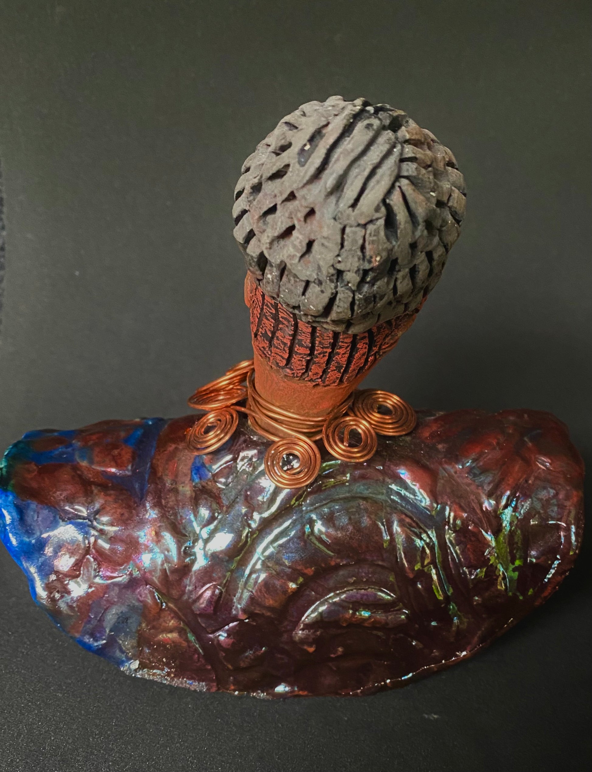 Meet Tia! Tia looks up with joy and anticipation! Tia stands 7" x 6" x 4" and weighs 1.90 lbs. She has a beautiful textured copper and blue robe. Tia has braided clay hair up in a bun. She has a honey brown complexion and soft light brown lips. Tia will make for great conversation in your home.  Free Shipping! Check out our Shipping and Return policy