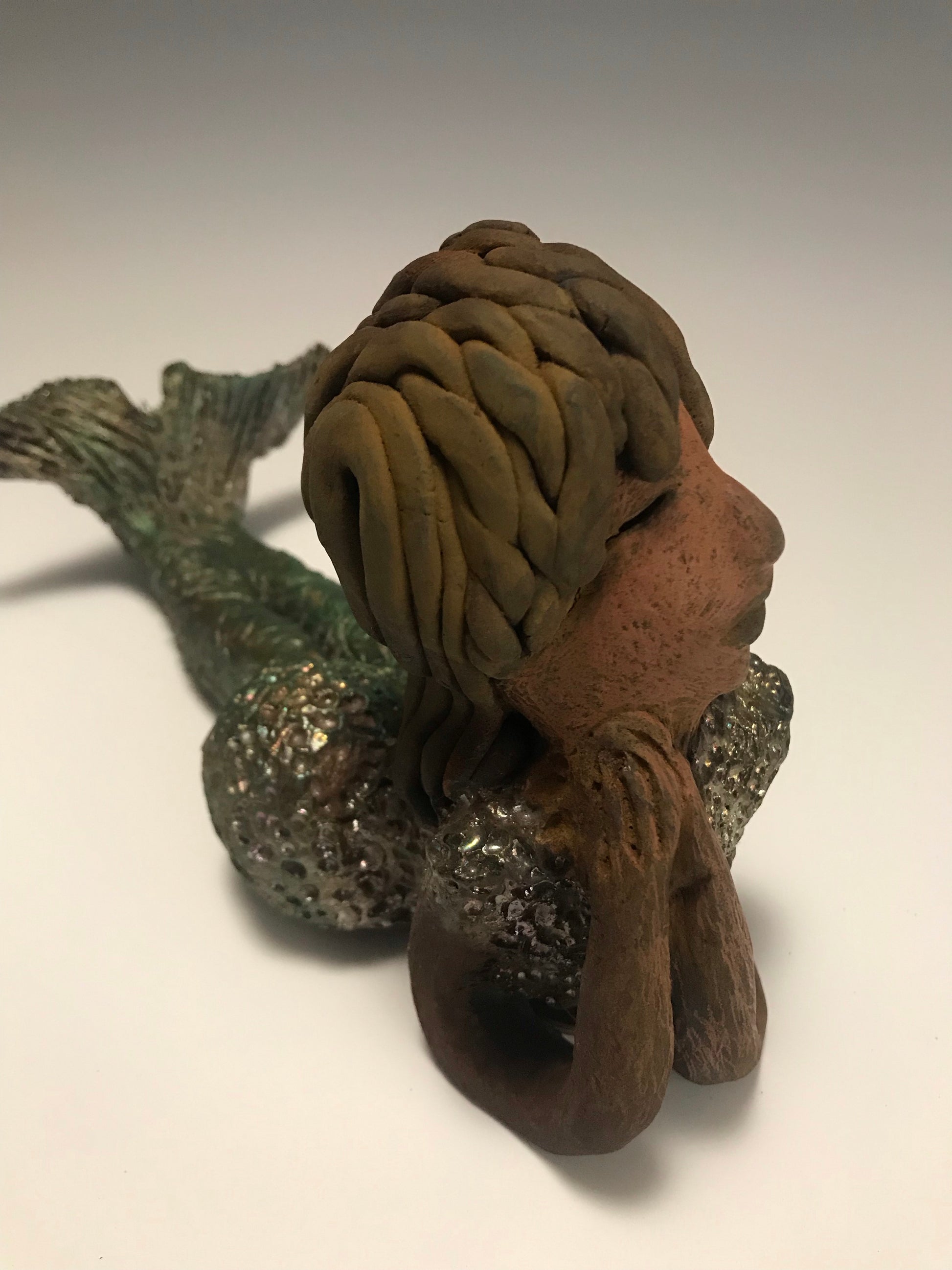 Meet Belinda!  Belinda is a voluptuous mermaid. She stands 6.5" X 5" 9.5" and weighs 2.04 lbs. Belinda has a dark chocolate complexion.      She wears a  dark smokey clay hairstyle.      She wears a glossy metallic swimsuit.     Belinda has a wide tail.     She will  definitely get somebody's attention.   Let Belinda get the conversation started at your home!