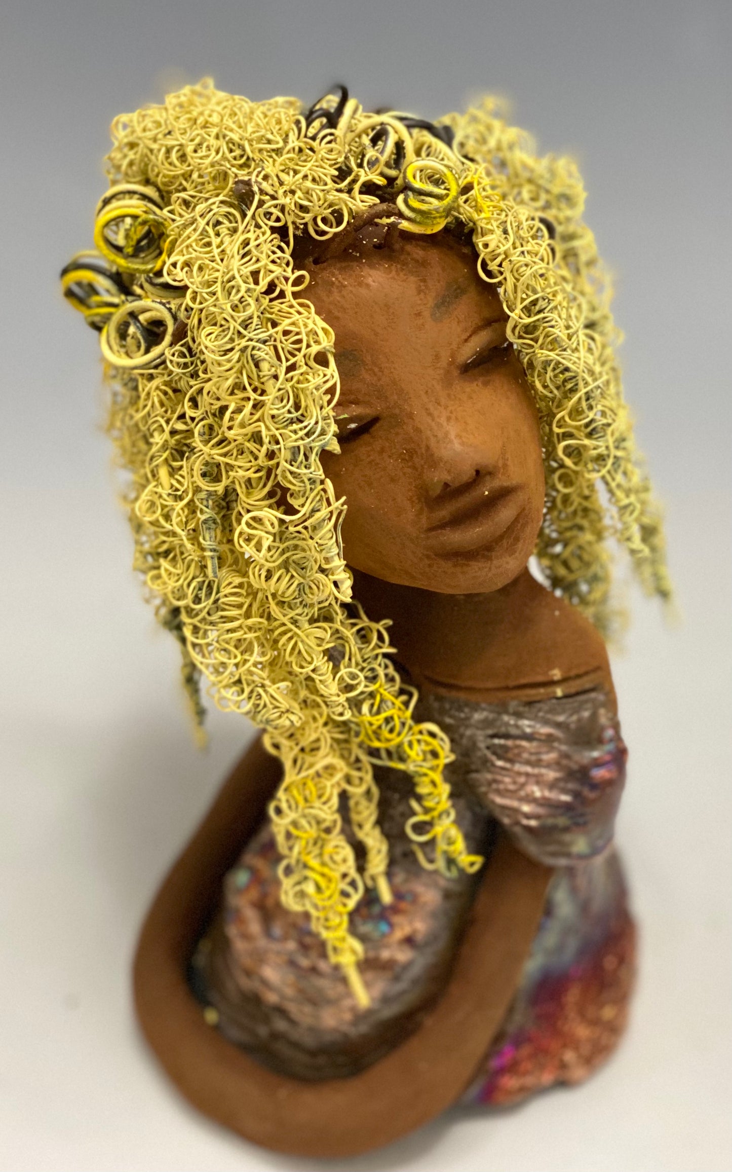 Valorie stands 8" x 4.5" x 4.5" and weighs 1.05 lbs. She has a lovely honey brown complexion with cocoa brown lips. She has long twisted wire locs hairstyle waist down! Valorie has a metallic copper antique glazed dress. She has over 75 feet of 16 and 24 gauge pale yellow wire for hair. It took over 7 hours just to do her hair! With eyes wide opened, Valorie has hope of finding a new home.