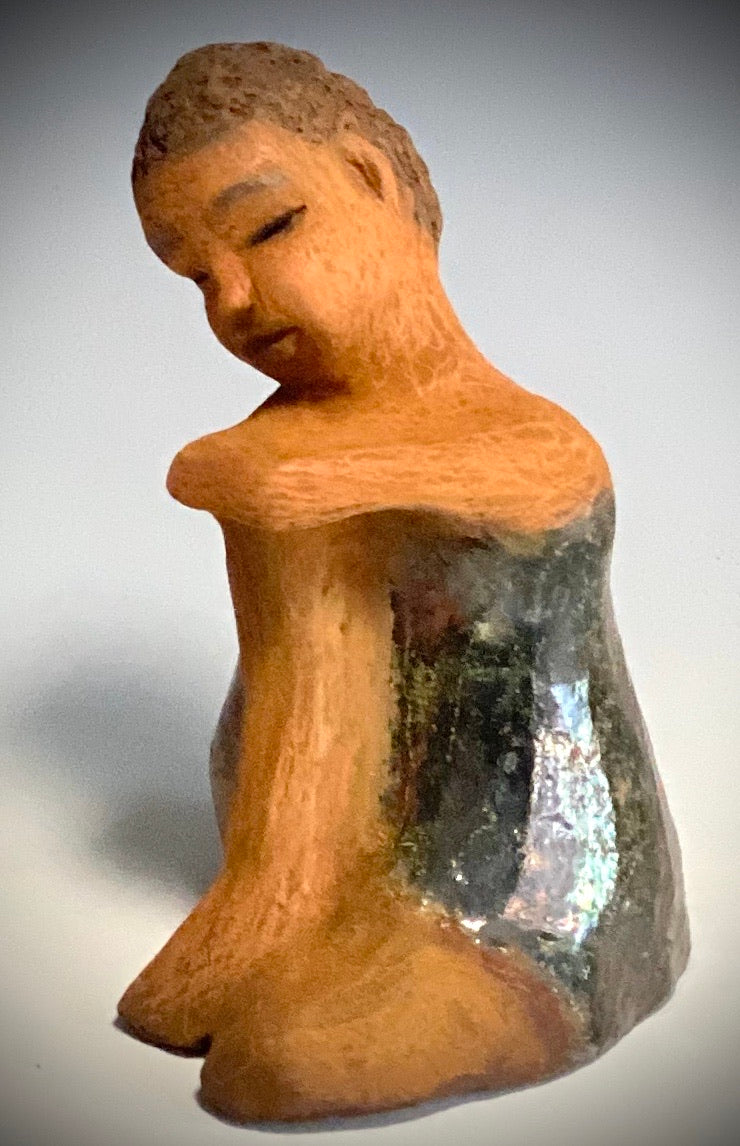 Carlos is one teen who will think before he reacts!   Carlos stands  6.5" x 4" x 5" and weighs 1.7 lbs. He wears a matching metallic green shirt and jeans . Carlos complexion is honey brown. He is thoughtful with a gentle spirit His  arms  are wrapped around  his knees as he waits on you.