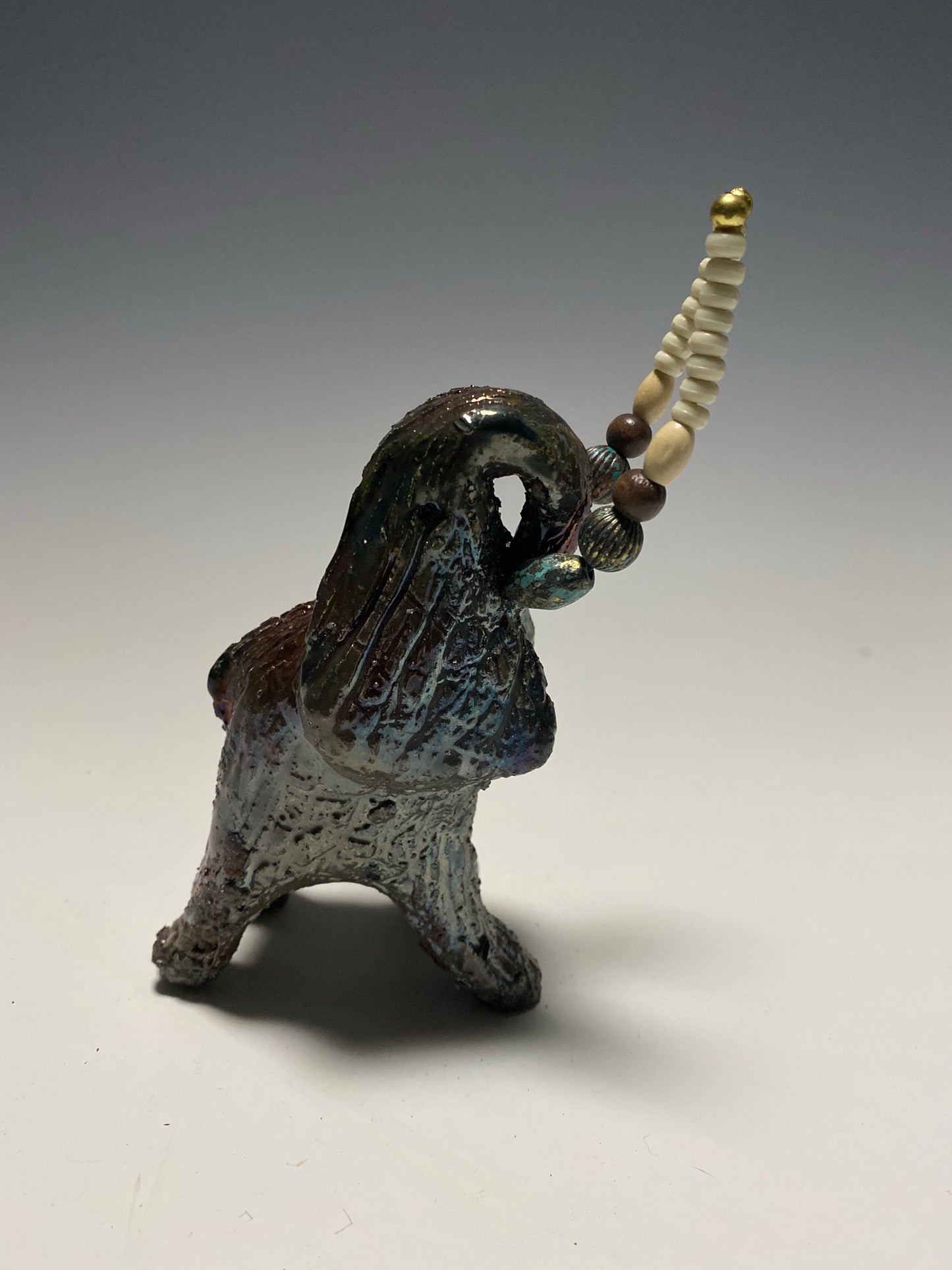 Raku Elephant Have you HERD!!!!!! Just one of these lovely Raku Fired Elephant will make an excellent gift for your friend, sorority or for your home’ special place centerpiece. 6" x 4" x 4" 1.7 lbs Beautiful copper metallic baby raku elephant Beaded white tusk. For decorative purposely only. Great Gift!