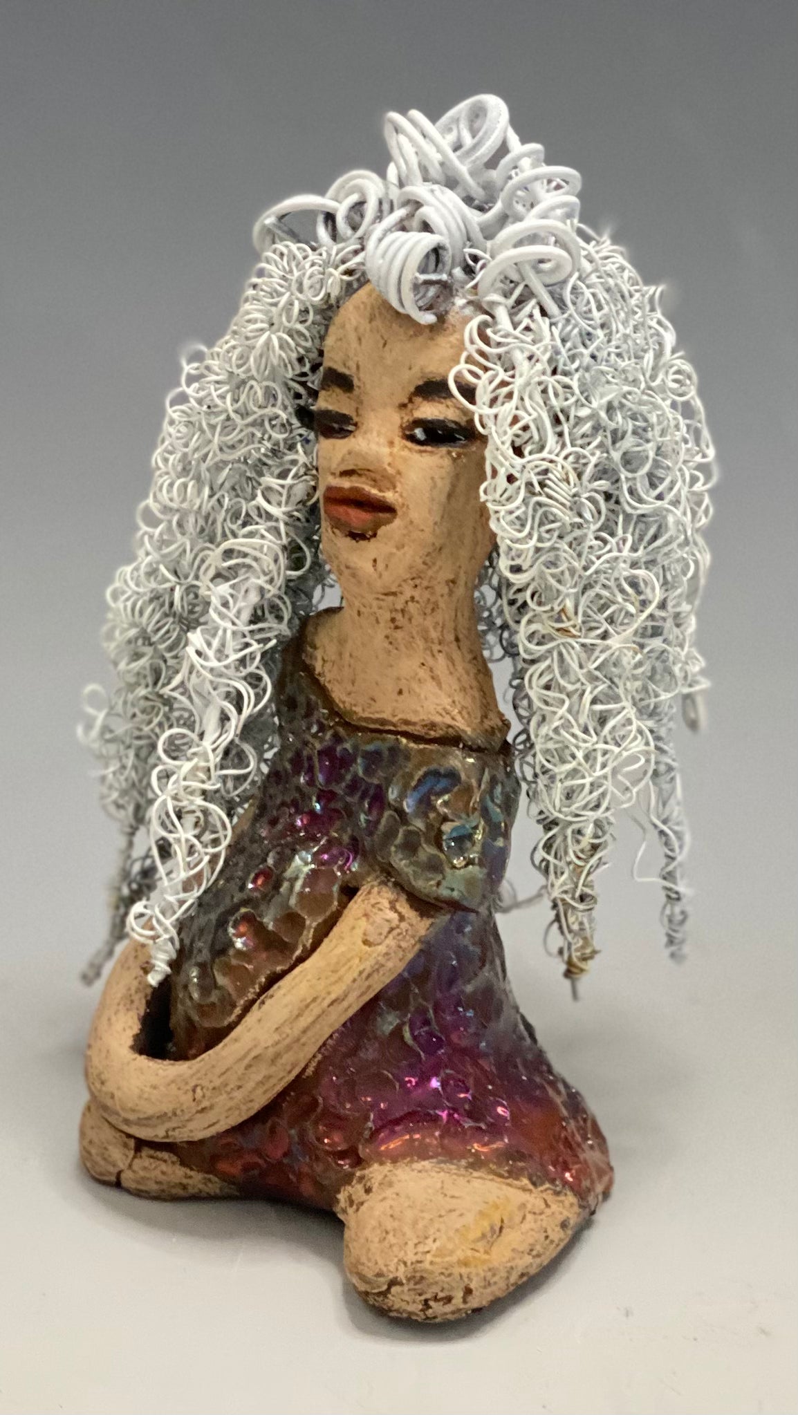 Alyssa stands 6" x 5" x 5" and weighs 12 ozs. She has a lovely honey brown complexion with cocoa brown lips. She has long twisted  white wire locs hairstyle waist down!  Alyssa has a metallic  copper antique glazed dress. She has over 75 feet of 16 and 24 gauge white wire for hair. It took over 3 hours just to do her hair! With  eyes wide opened, Brianna has hope of finding a new home.     You will love having Alyssa. She will attract and spark conversation with guest in your home!