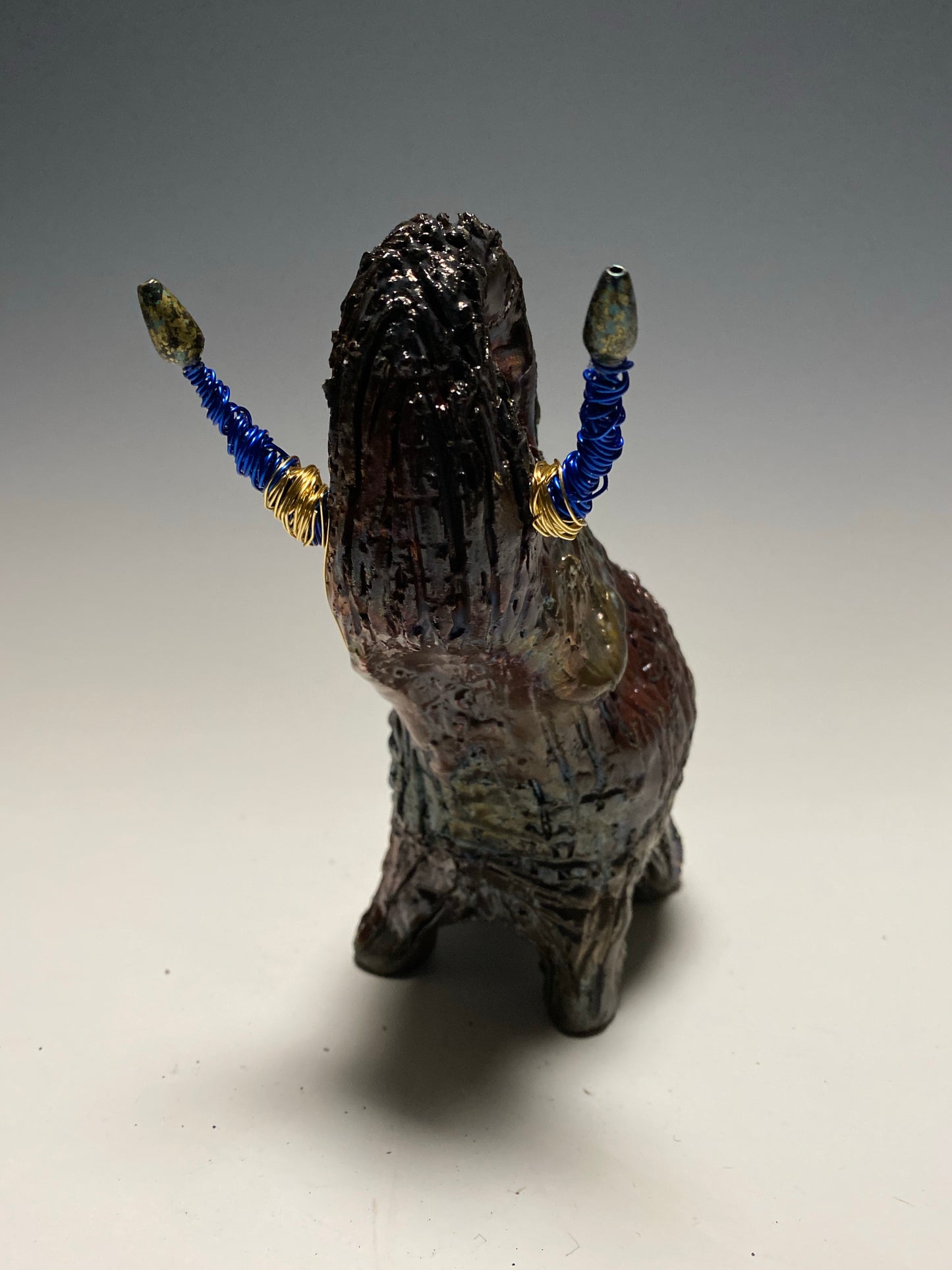Raku Elephant Have you HERD!!!!!! Just one of these lovely Raku Fired Elephant will make an excellent gift for your friend, sorority or for your home’ special place centerpiece. 6" x 4" x 4" 1 lbs Beaded tusk with blue and gold wire Beautiful colorful metallic raku elephant For decorative purposely only