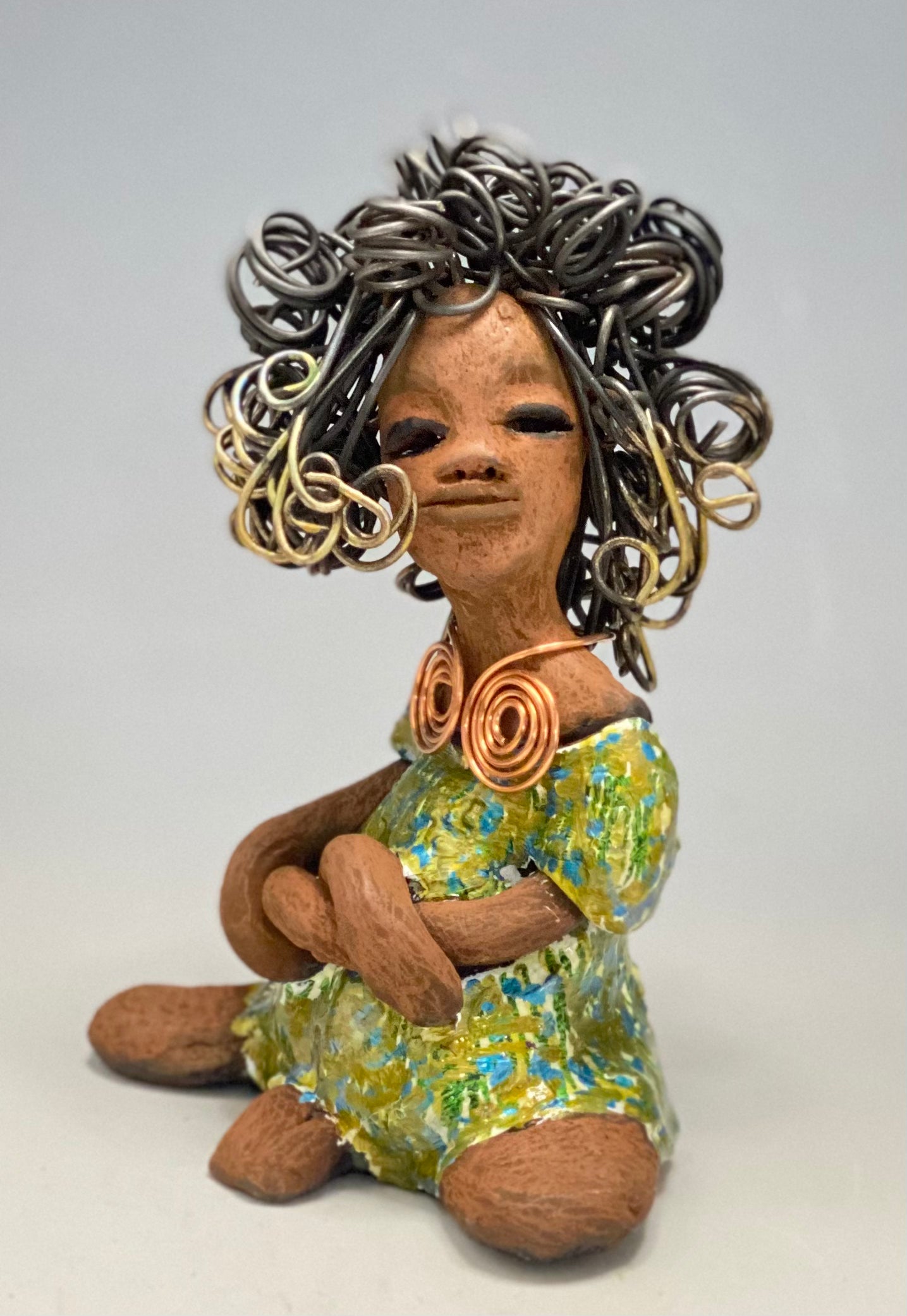 Jayla stands 7" x 5" x 4.5" and weighs 14 ozs. She has a lovely honey brown complexion with cocoa brown lips. She has a big hairstyle! Brianna has a colorful blue green antique glazed dress. She has over 15 feet of 16 gauge wire for hair. It took over 2hours just to do her hair! With eyes wide opened, Jayla has hope of finding a new home. You will love having Jayla! She will attract and spark conversation with guest in your home!