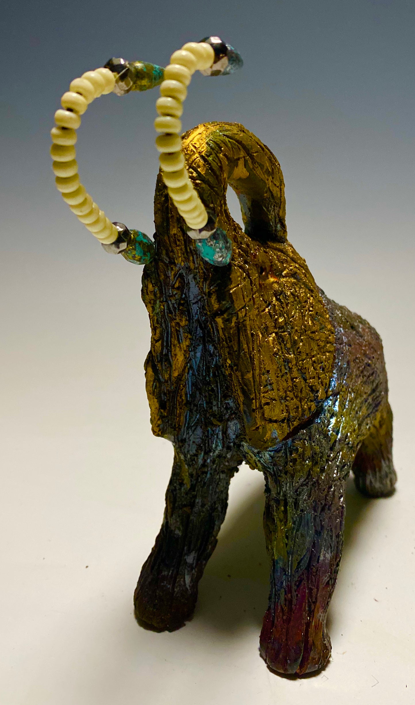 Raku Elephant Have you HERD!!!!!! Just one of these lovely Raku Fired Elephant will make an excellent gift for your friend, sorority or for your home’ special place centerpiece. 7" x 4" x 4" 1.3 lbs White beaded with silver and blue tusk Beautiful metallic raku colors For decorative purposely only.