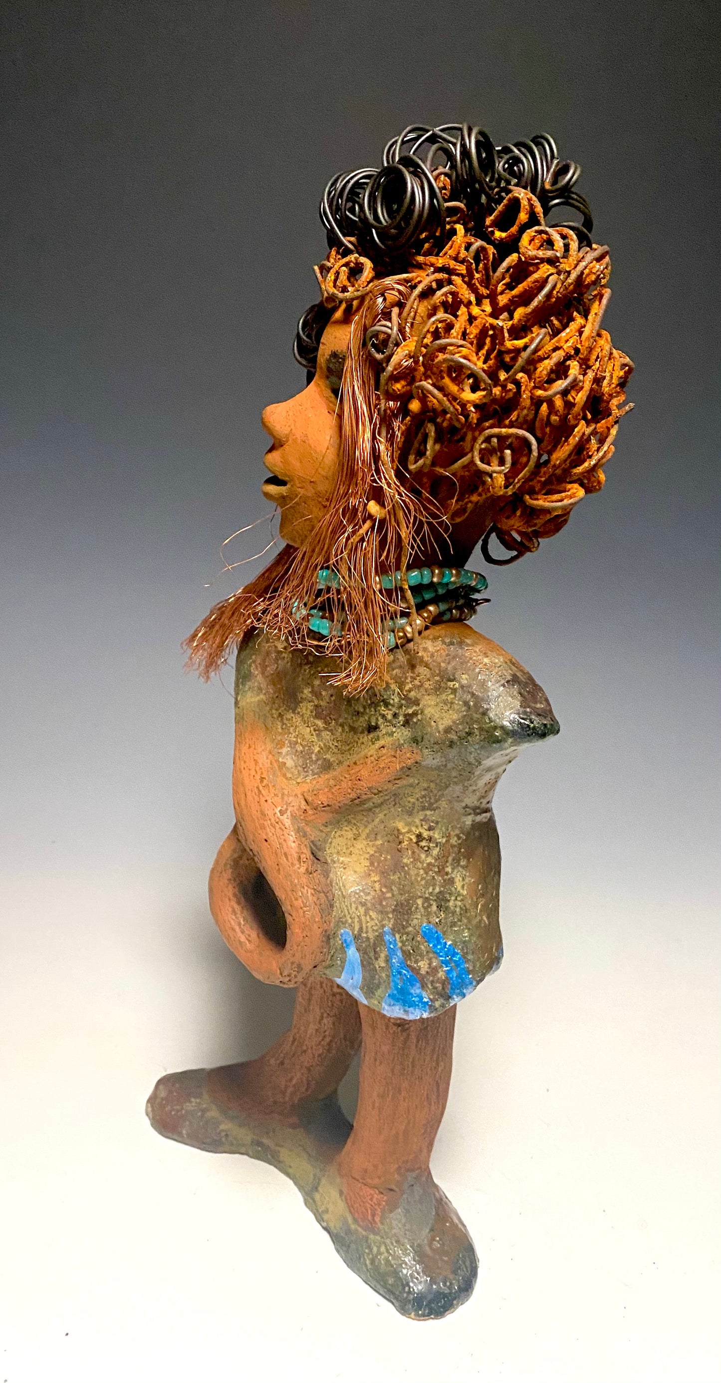 Meet Ernestine! What a joy to be around a young lady like Ernestine! She is one of many who has a polite gentle spirit! Ernestine stands 13" x 5" x 4" and weighs 3.19 lbs. Ernestine has a lovely honey brown complexion. Her hair is made of multiple strands of thin copper wire and two tone black and rusted 16 gauge wire. She has a textured colorful copper metallic dress. Ernestine is a young woman full of pride and joy. If you like sophisticated sculptures, Ernestine will bring joy and peace to your home.