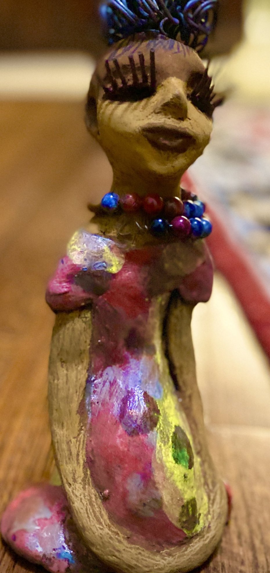 You know someone like Tiffanie. One who reaps elegance and sophistication!  Tiffanie stands 9”x 4" x 4" and weighs 1.03 lbs.  She has a two tone light beige complexion with 2 feet of 16 gauge spiral coiled wire hair.  Tiffanie metallic copper red and yellow  dress is accented by a multicolored beaded necklace. Tiffanie’s long lashes and  black eye shadow gives her a distinguished mystical look.
