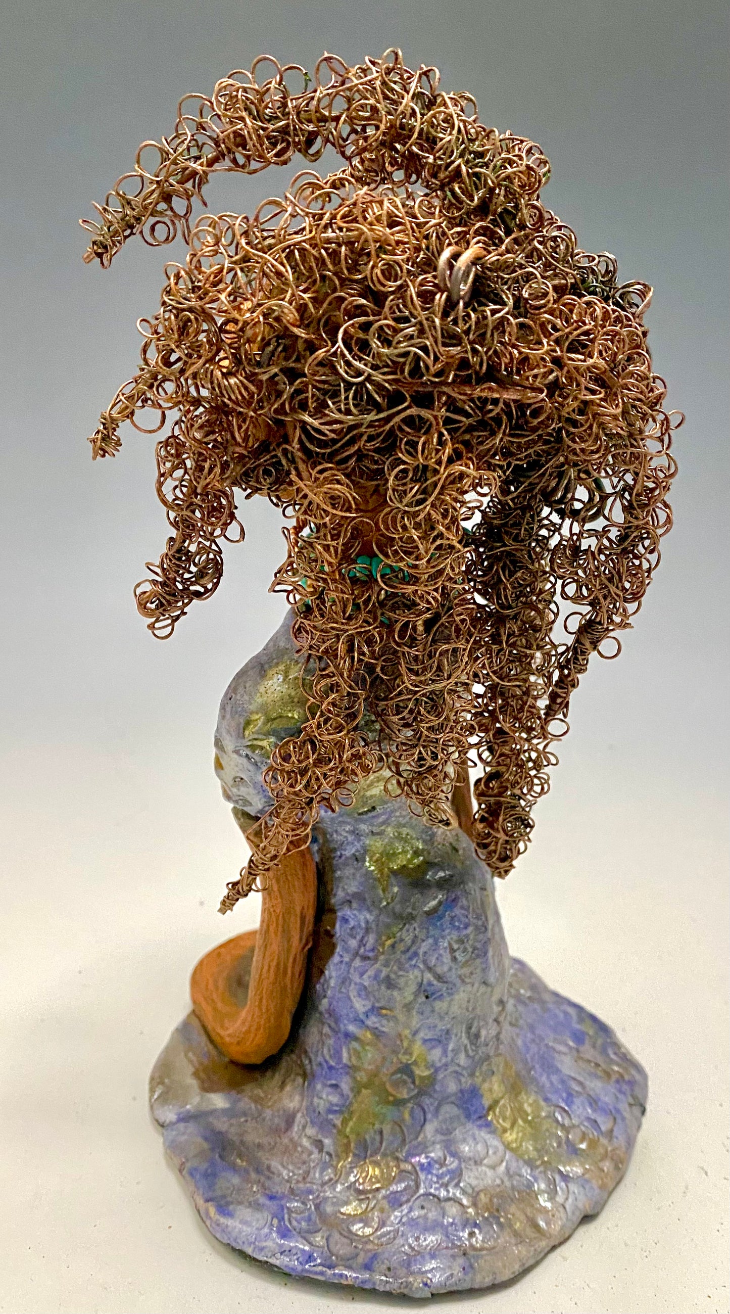 Meet Janae'! She has grown a head full of Hair! Janae' stands 8" x 5" x 4" and weighs 1.03 lbs. She has a lovely honey brown complexion with lovely reddish brown lips. Janae' wears a clay braided hairstyle. Janae' has a colorful metallic blue and gold glazed dress. She wears a blue and antique copper beaded necklace. With eyes wide opened, Janae' has hopes of finding a new home.