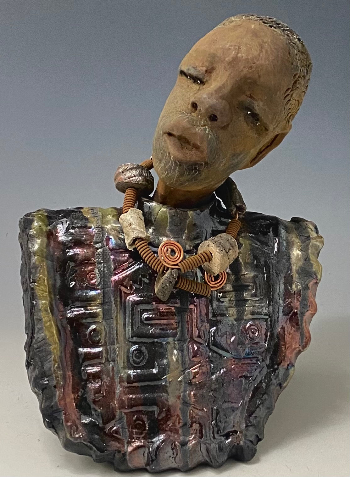 Meet James! James stands 10" x 7" x 5.5" and weighs 3.5lbs. James wears a colorful metallic gold, blue and copper dashiki. He is bald and bearded and partially grey. Yes ,,,,,,He is one of few Men found in the Herdew collection!