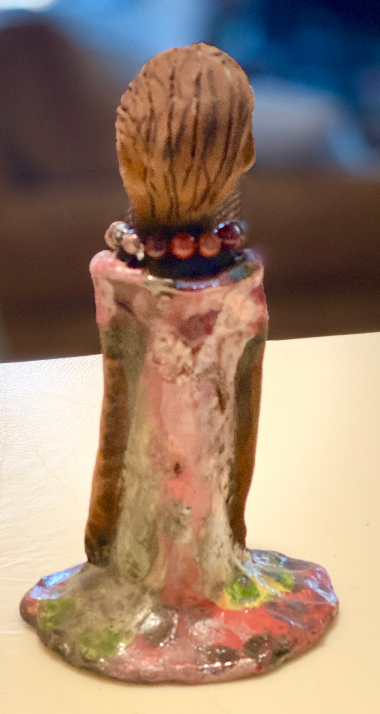 Mena long loving arms rest beside her multicolored copper green dress. Mena is a sophisticated lady that will grace your home.