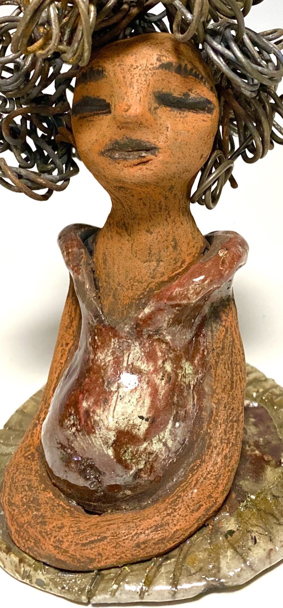 Meet Carleen! Carleen stands 6" x 4" x 4" and weighs 12 ozs. Carleen has a honey brown complexion with 16 gauge curled wire hair. She wears an copper metallic dress. Carleen has her long loving arms at her side as she rest and waits.