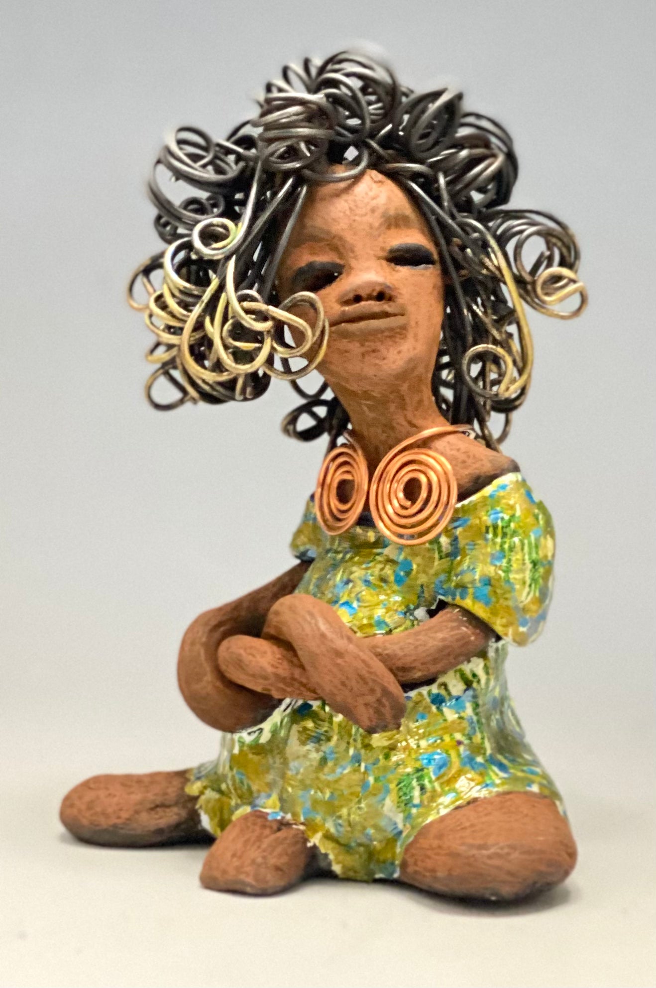 Jayla stands 7" x 5" x 4.5" and weighs 14 ozs. She has a lovely honey brown complexion with cocoa brown lips. She has a big hairstyle! Brianna has a colorful blue green antique glazed dress. She has over 15 feet of 16 gauge wire for hair. It took over 2hours just to do her hair! With eyes wide opened, Jayla has hope of finding a new home. You will love having Jayla! She will attract and spark conversation with guest in your home!