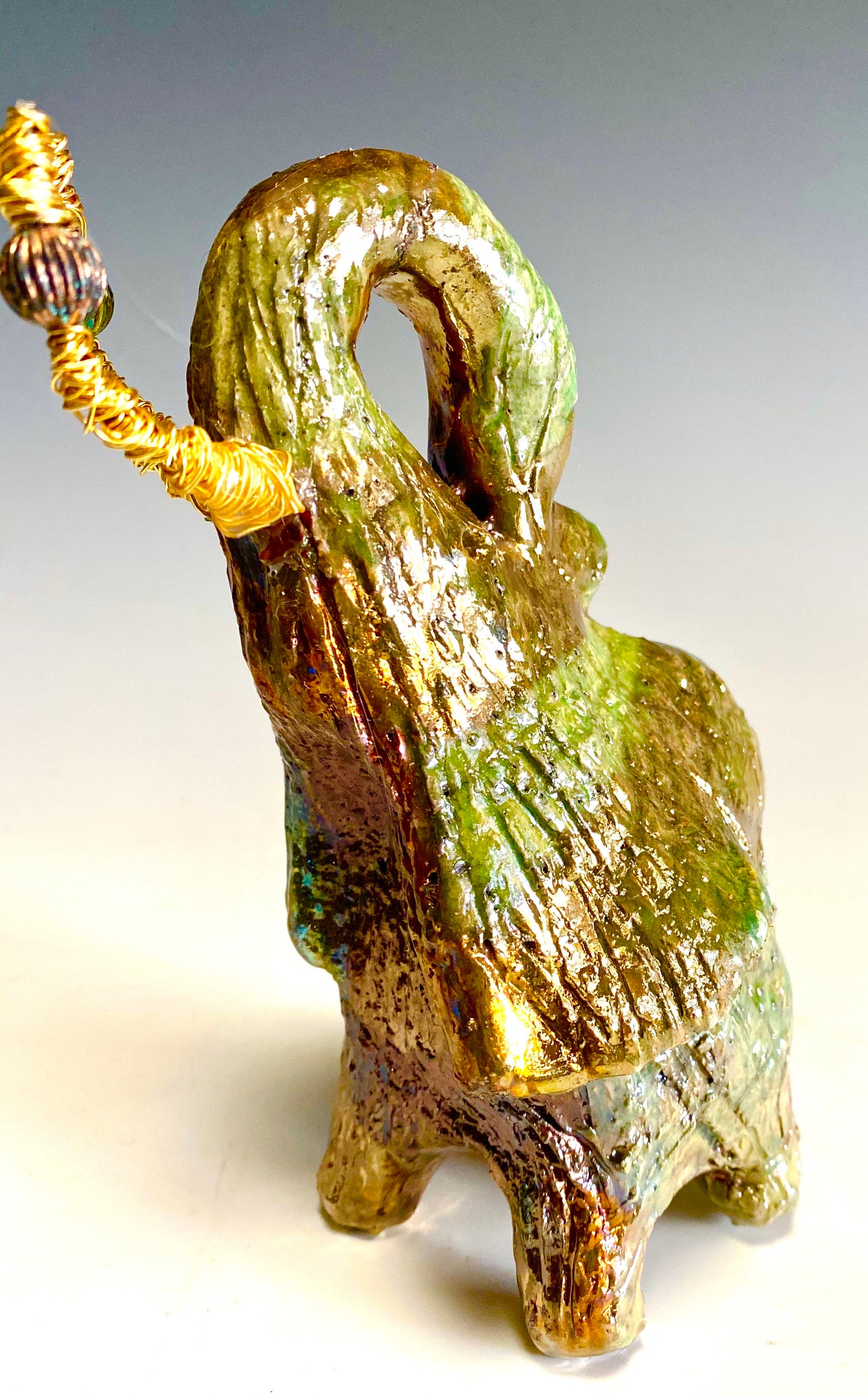 Raku Elephant Have you HERD!!!!!! Just one of these lovely Raku Fired Elephant will make an excellent gift for your friend, sorority or for your home’ special place centerpiece. 6" x 4" x 5" 14 ozs. Beautiful copper, green and gold metallic raku elephant Gold beaded tusk For decorative purposely only.