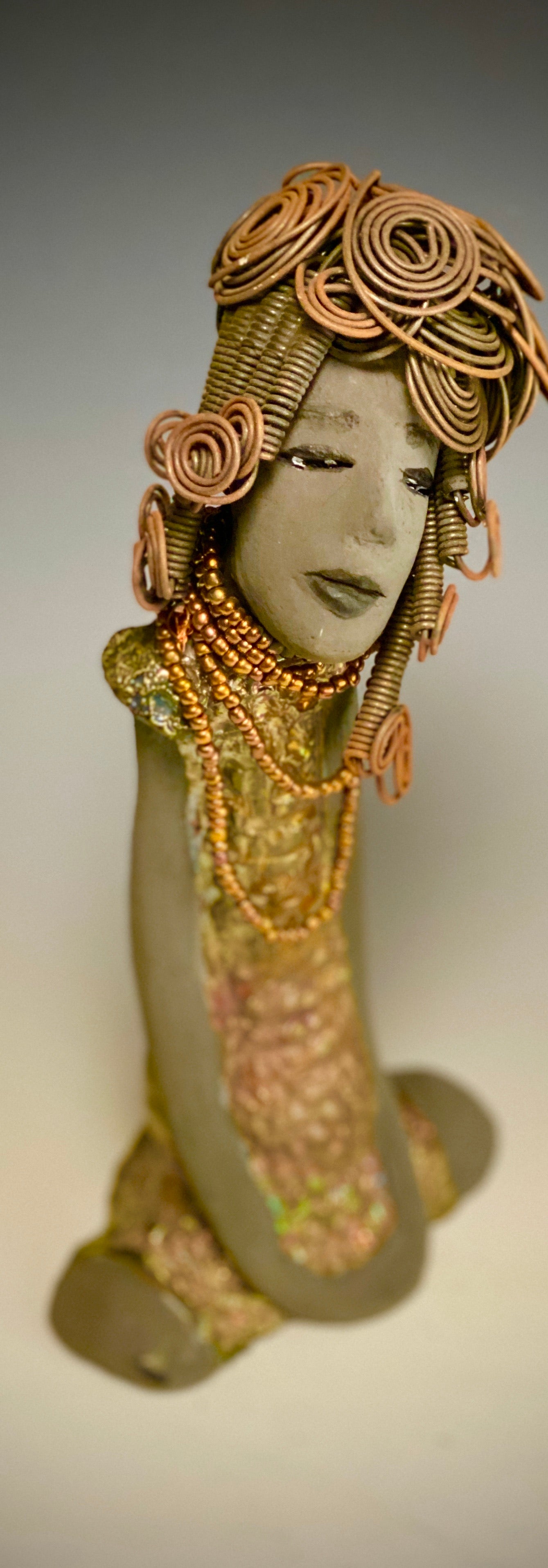 Meet Carolyn! Carolyn stands 12" x 6" x 4" and weighs 2.4 lbs. Carolyn as a lovely smokey dark complexion with honey brown eye shadow.' She wears a textured glossy copper metallic dress. Carolyn's long loving arms are at her side. It took three hours to complete her 16 gauge wire Herdew! Give Carolyn a special place in your home