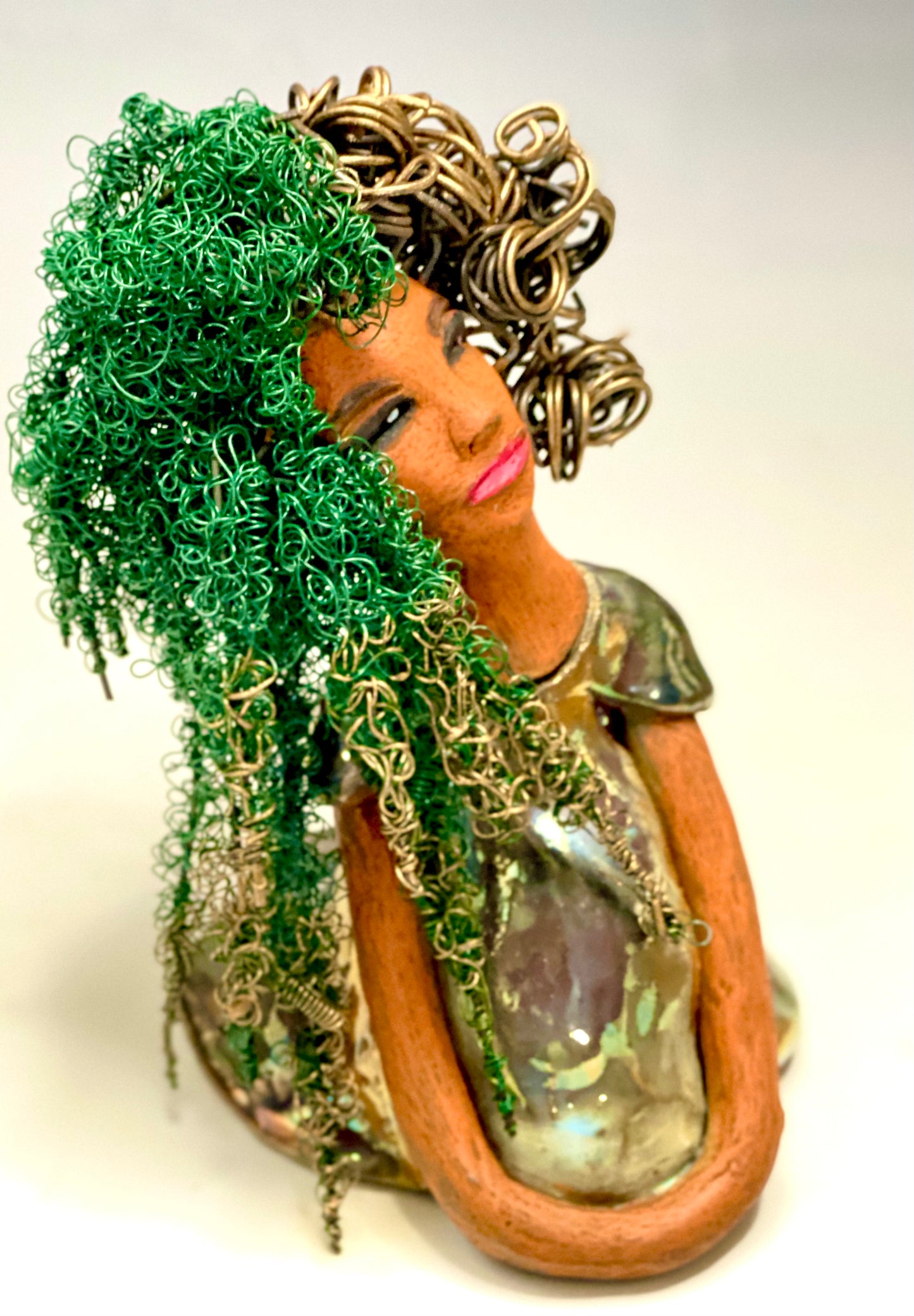 Diane stands 7" x 6" x 5.5" and weighs 1.9 lbs. She has a lovely honey brown complexion with reddish brown lips. She has long twisted wire locs hairstyle waist down! Diane has a very colorful metallic copper green antique glazed dress. She has over 75 feet of 16 and 24 gauge wire for hair. It took over 6 hours just to do her hair! With eyes wide opened, Diane has hope of finding a new home.