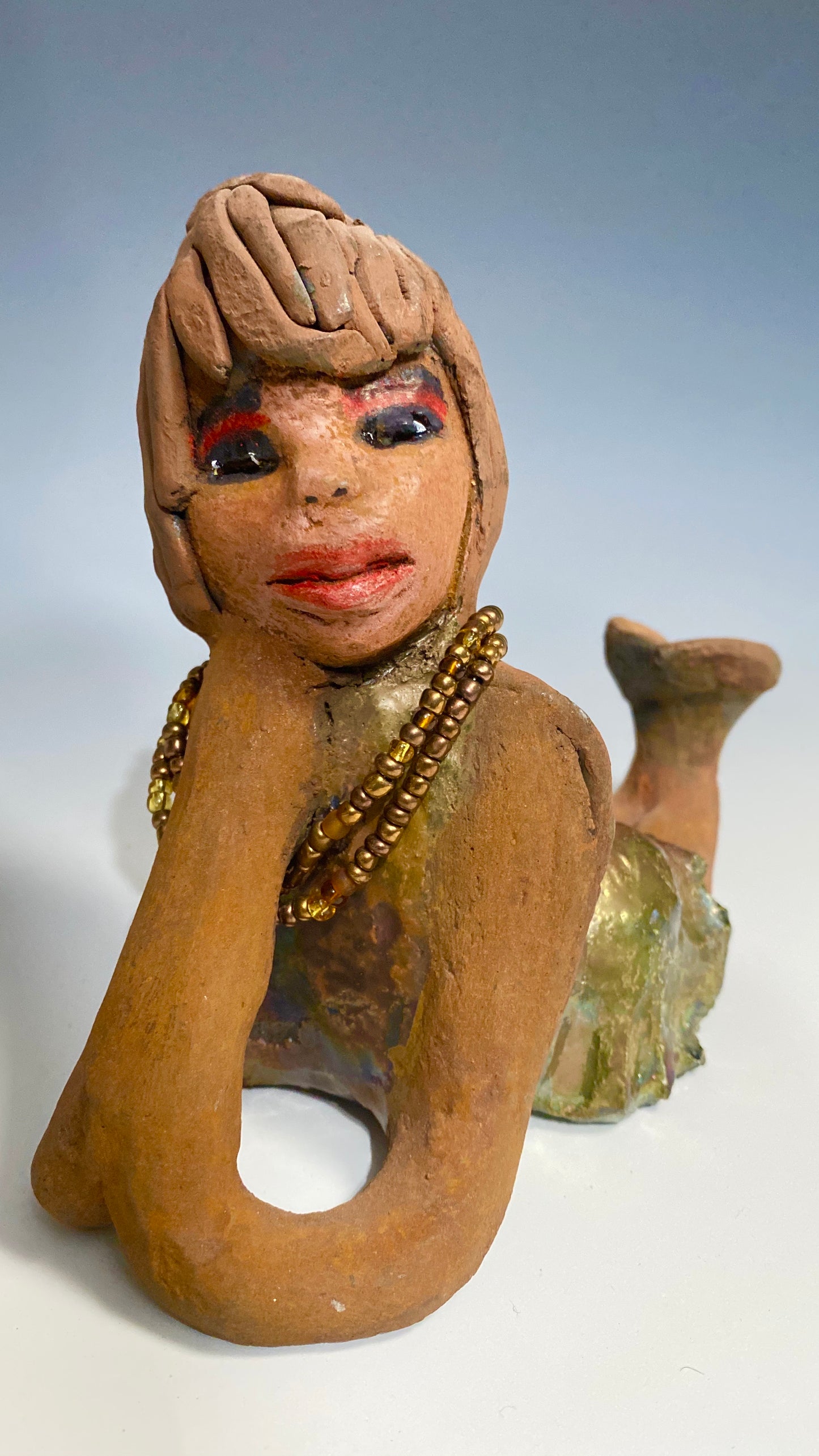 Meet Devonte! Devonte stands 8" x 6" x 4" and weighs 1.06 lbs. Devonte has a awesome honey brown complexion. She has braided clay hair. Devonte has long loving arms. She wears a metallic copper dress with red orange beads. Give Devonte a special place in your home!