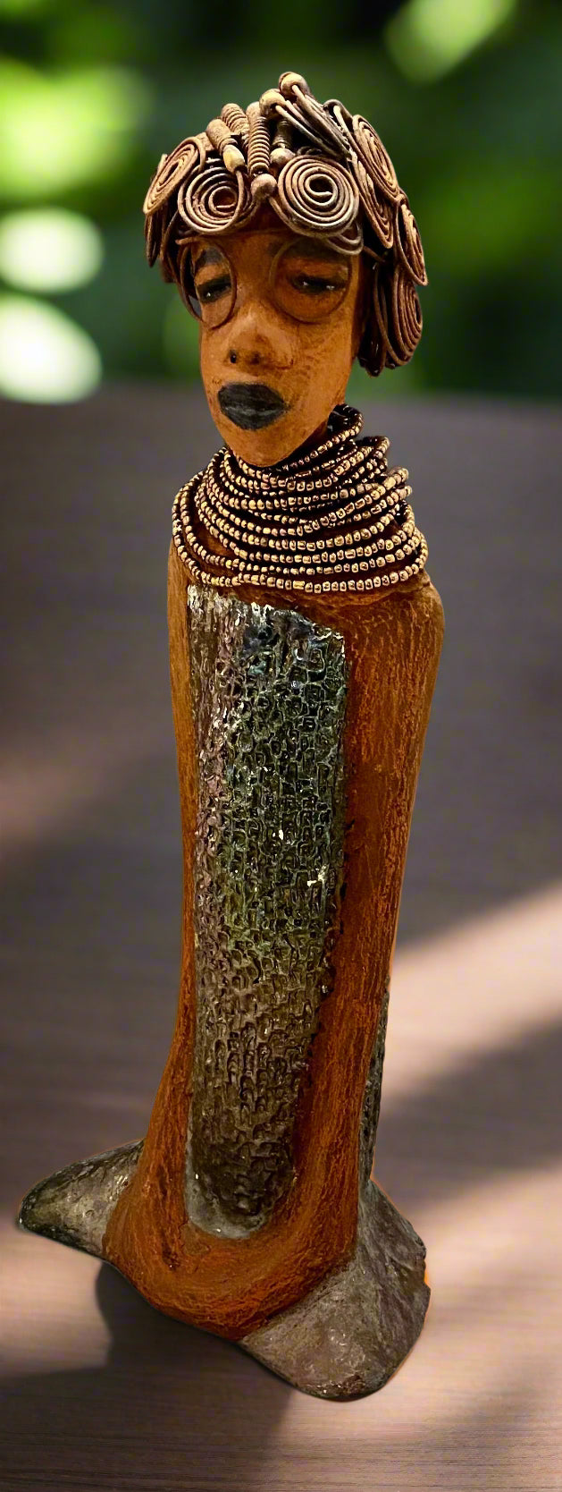 Meet Ernestine! Ernestine stands 18' x 6" x 5" and weighs 5.03 lbs. Ernestine has a lovely honey brown complexion. She has a shimmering copper dress with a huge seed bead necklace. Ernestine is a tall girl with long loving arms. It took several hours to style Ernestine's 16 gauge wire hair! With eyeglasses ,she looks as if she's dreaming or in disbelief. Ernestine is indeed a sophisticated looking lady! Give Ernestine a new place to stay in your home!