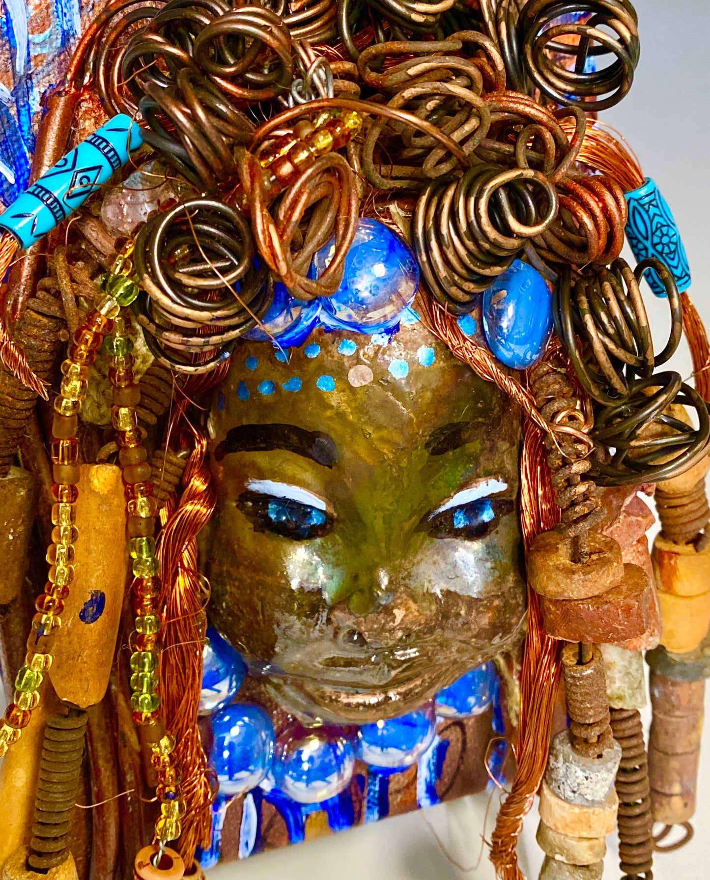 Tyra is mounted on a 5"x 7" painted canvas. I spent about 2 hours or more just fixing Tyra's hair and attaching beads! Tyra has over 30 feet of 16 gauge wire for hair and over 30 raku and wooden beads. Tyra has a silver blue and antique copper crackle face and lips. Tyra is ready to be hung!
