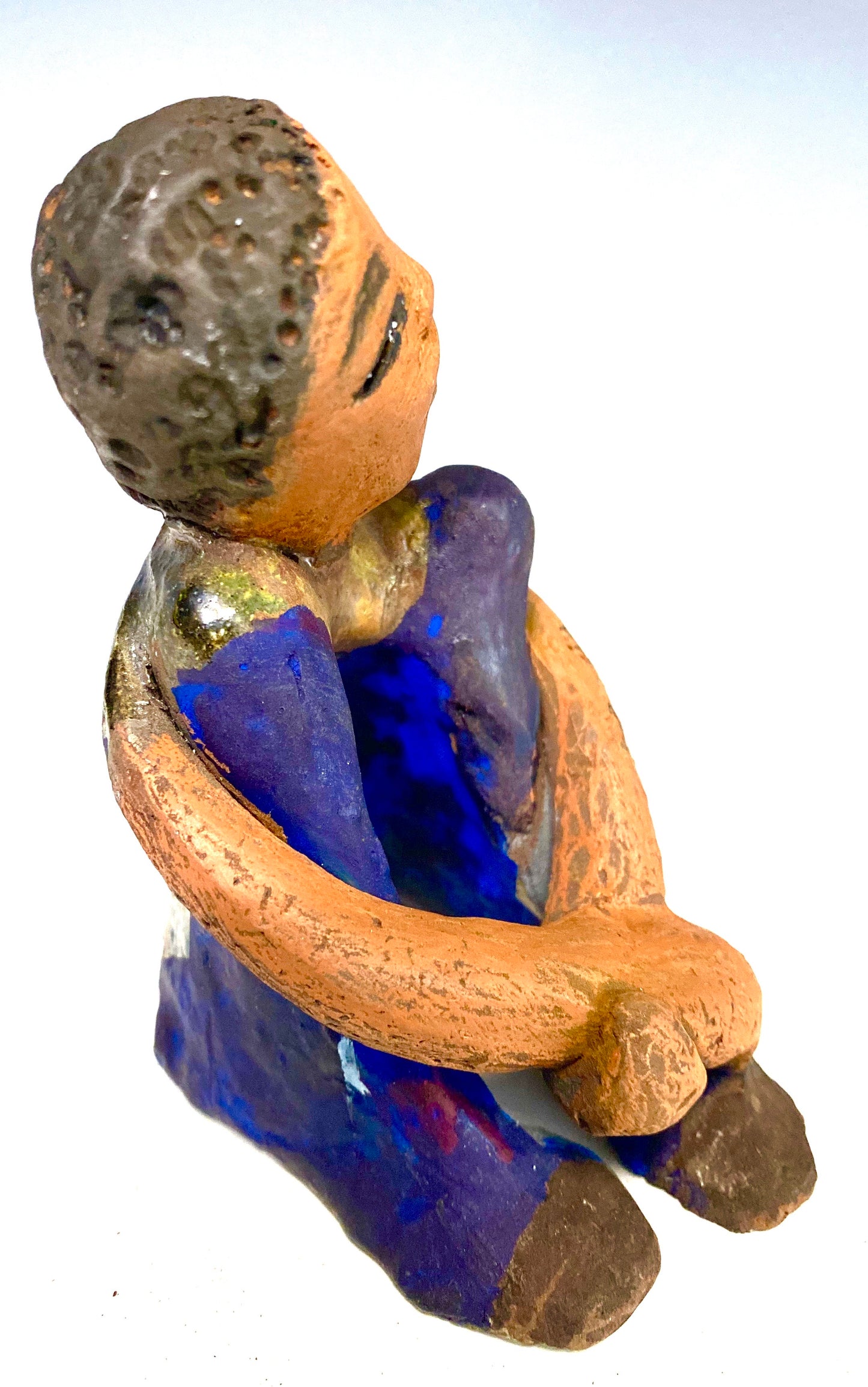 Paul is a Handsome Mischief Guy! Do you see the wit in his face? Paul stands 4.5"x 3" x 3" and weighs 6.9 ozs. He has a shimmery metallic tee shirt. Paul's complexion is honey brown. His arms are folded around his legs as he ponders another mischief moment!