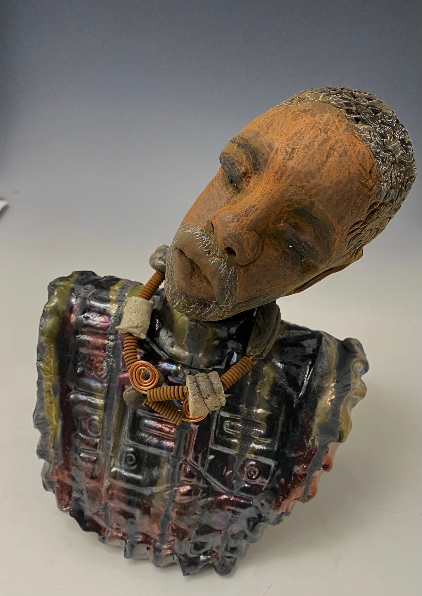 Meet James! James stands 10" x 7" x 5.5" and weighs 3.5lbs. James wears a colorful metallic gold, blue and copper dashiki. He is bald and bearded and partially grey. Yes ,,,,,,He is one of few Men found in the Herdew collection!