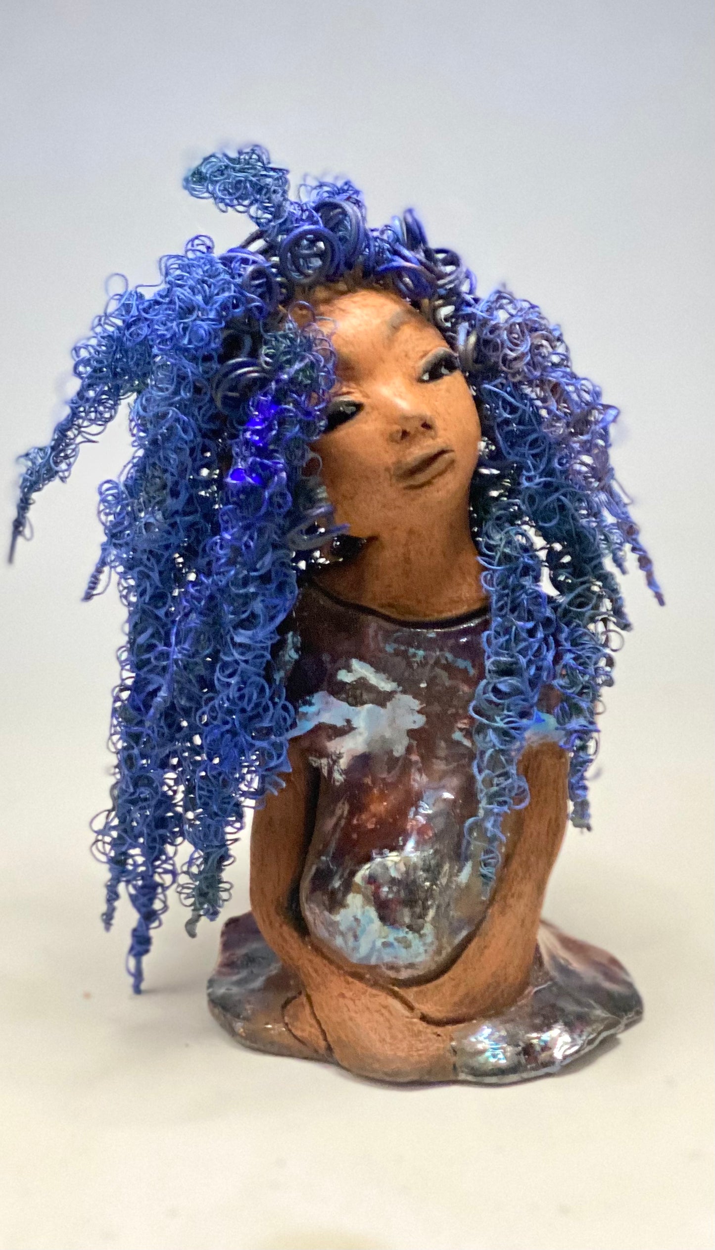 Rachel Rachel stands 8" x 6" x 5.5" and weighs 1.9 lbs. She has a lovely honey brown complexion with cocoa brown lips. She has long twisted wire locs hairstyle waist down! Rachel has a very colorful metallic copper blue antique glazed dress. She has over 75 feet of 16 and 24 gauge wire for hair. It took over 6 hours just to do her hair! With eyes wide opened, Rachel has hope of finding a new home.